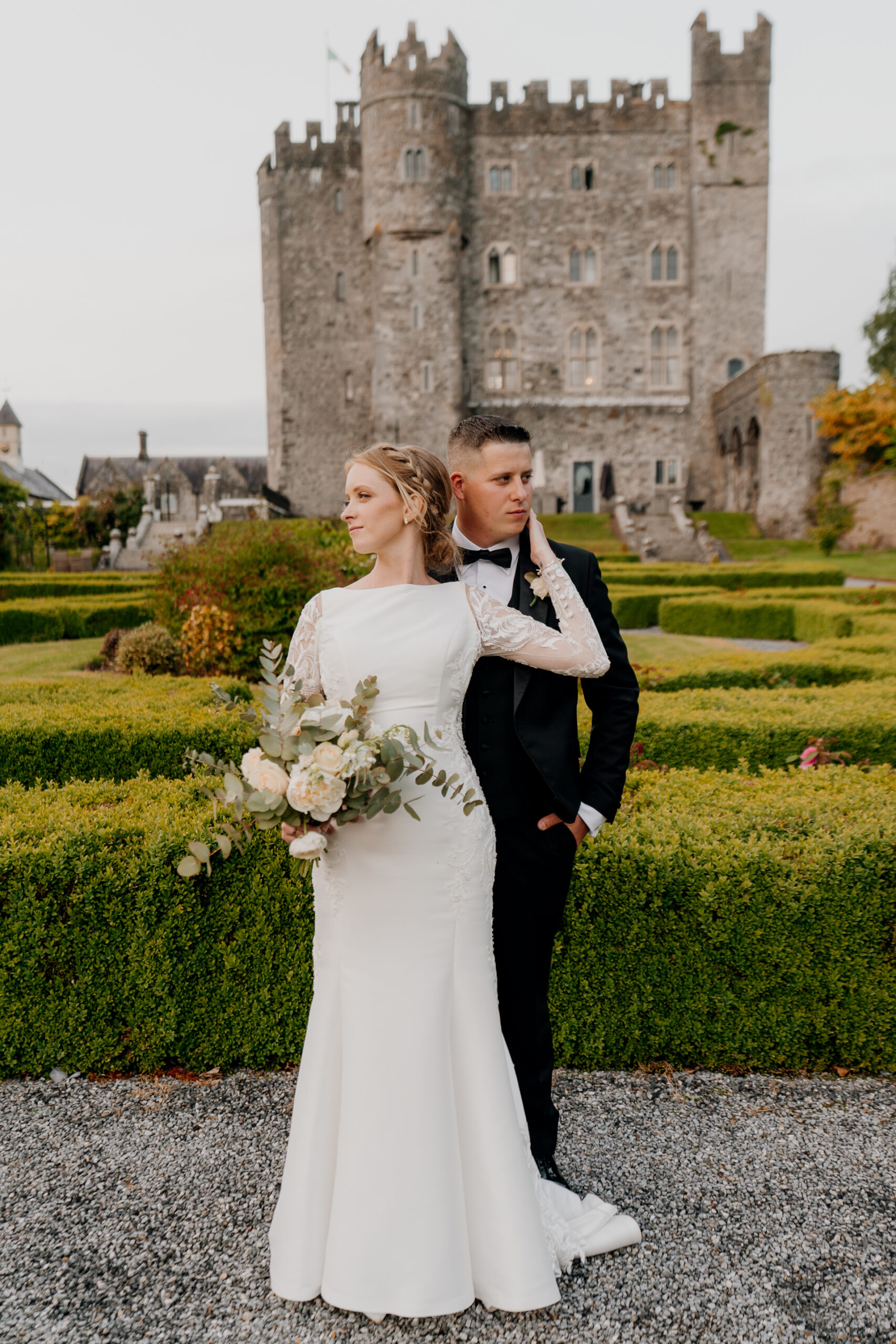 A man and woman posing for a picture in front of a castle