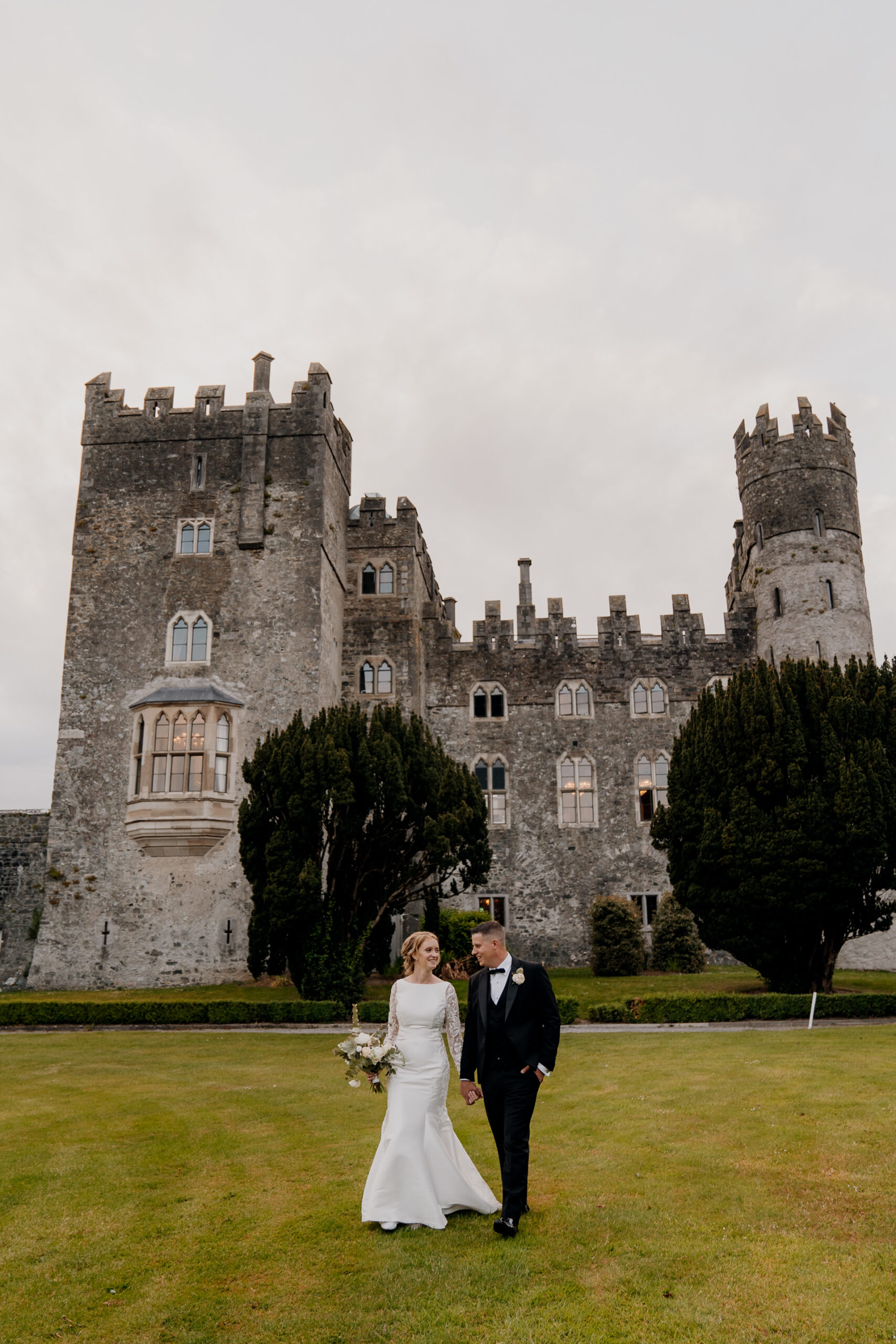 A man and woman in front of a castle