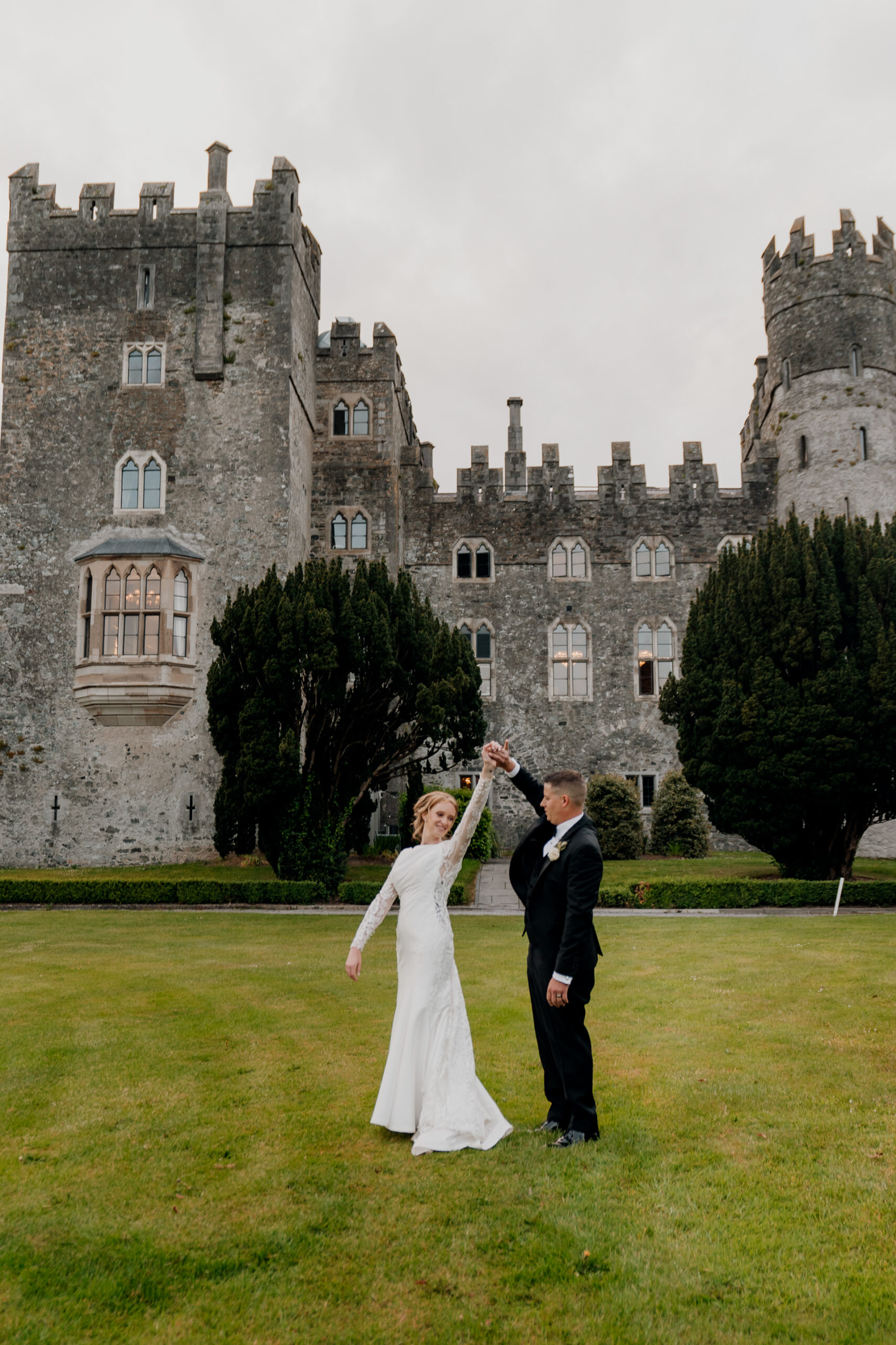 A man and woman in front of a castle