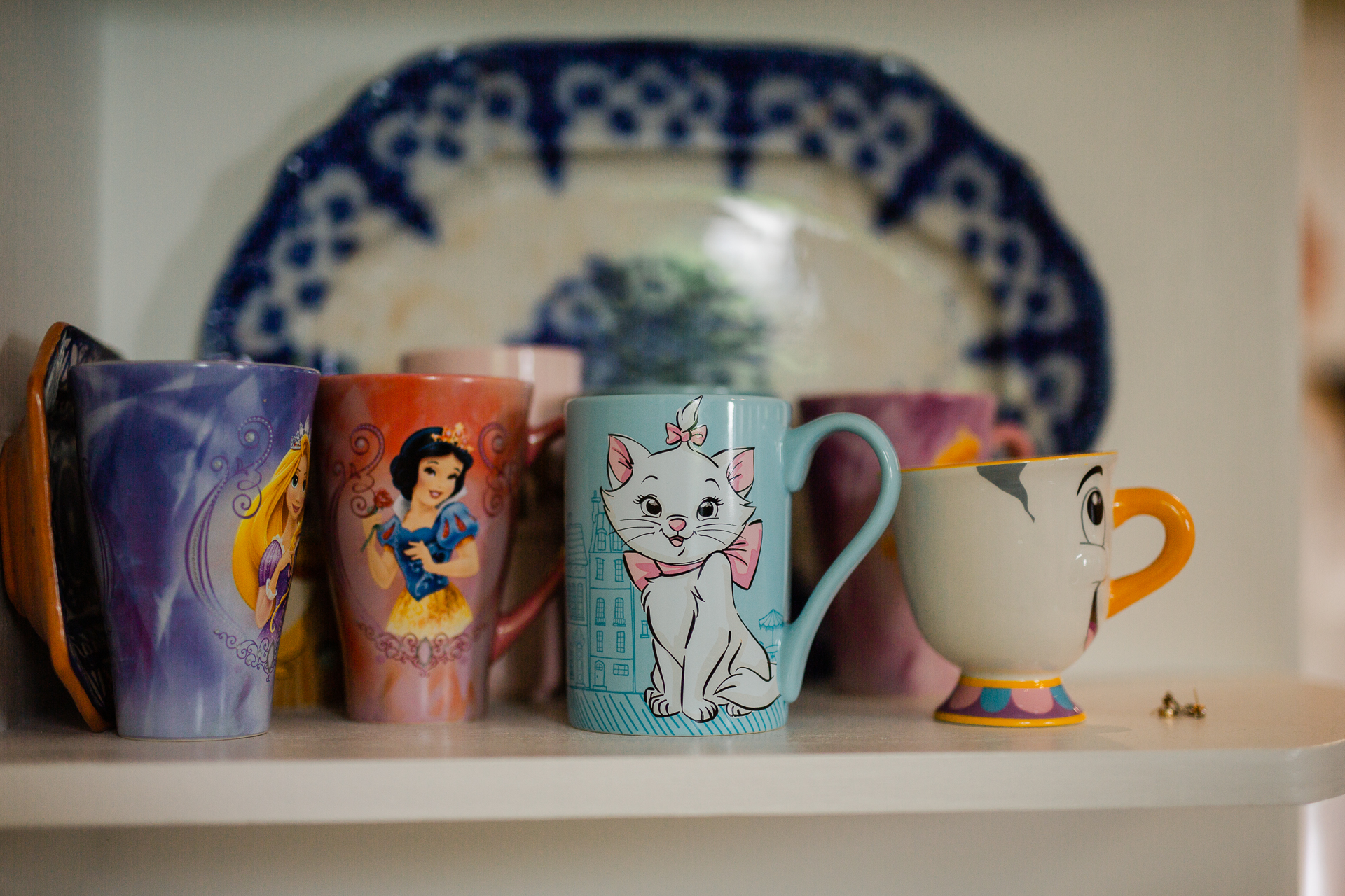 A shelf with tea cups and a teapot