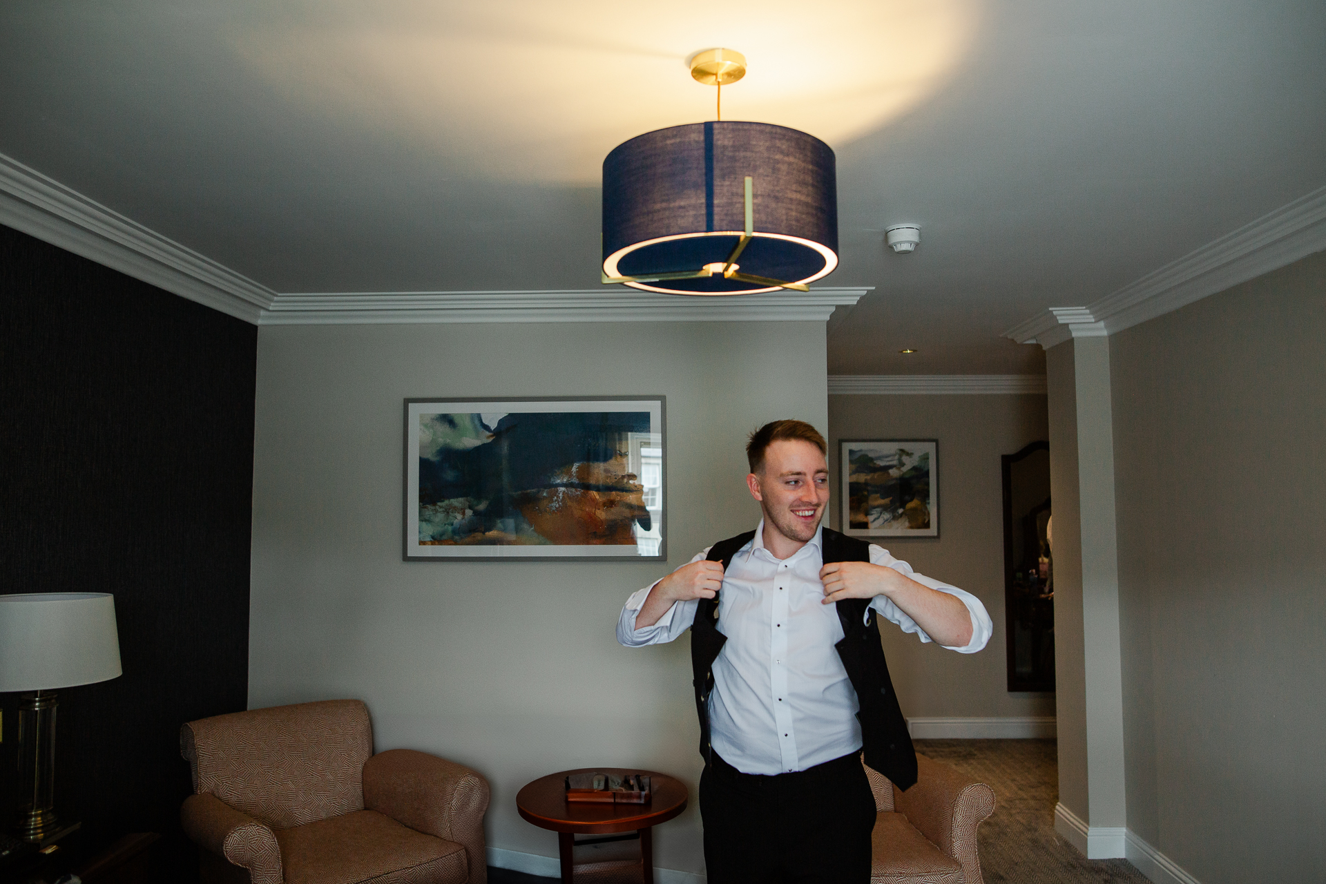 A person standing in a room with a chandelier and a couch