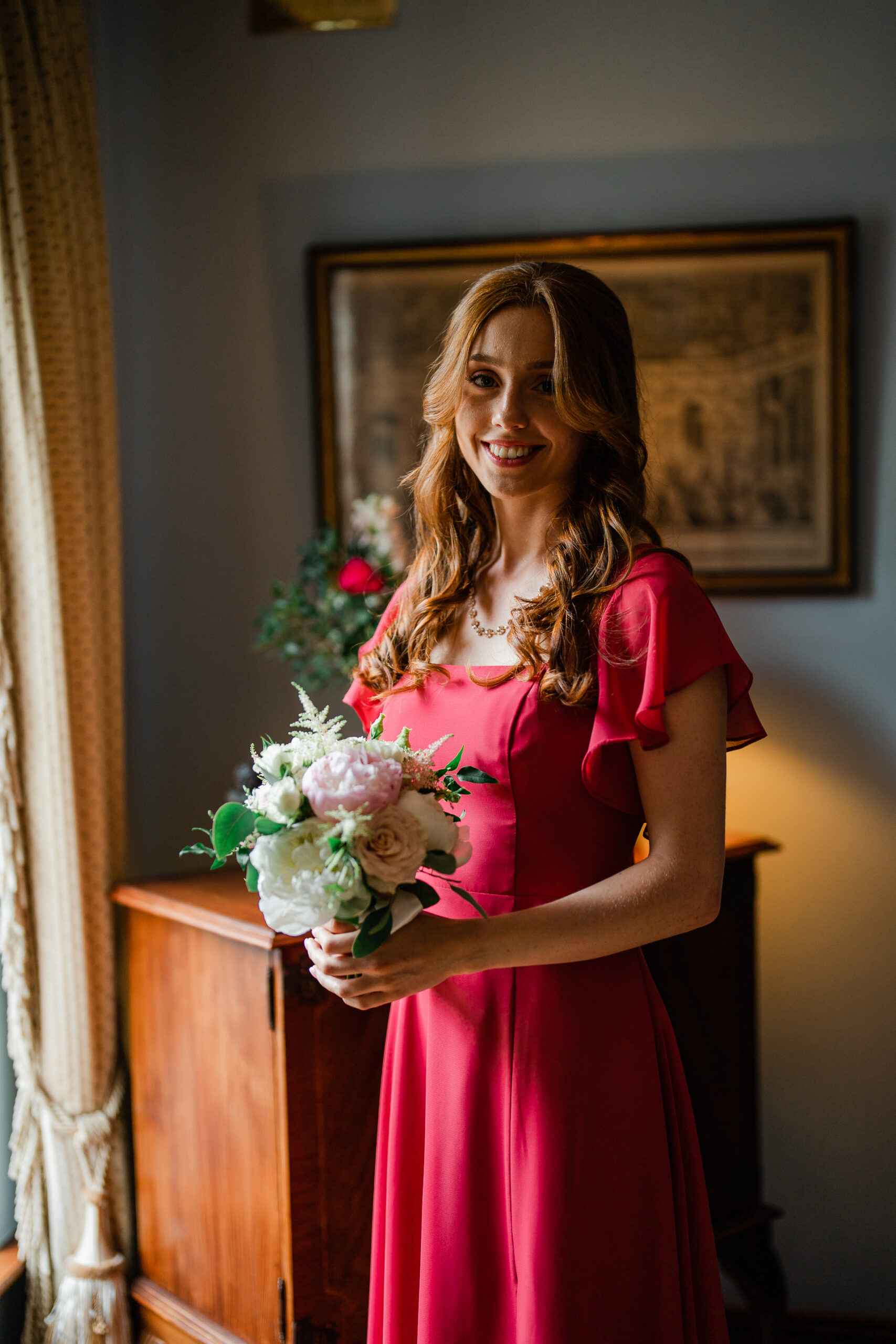 A woman in a red dress holding flowers