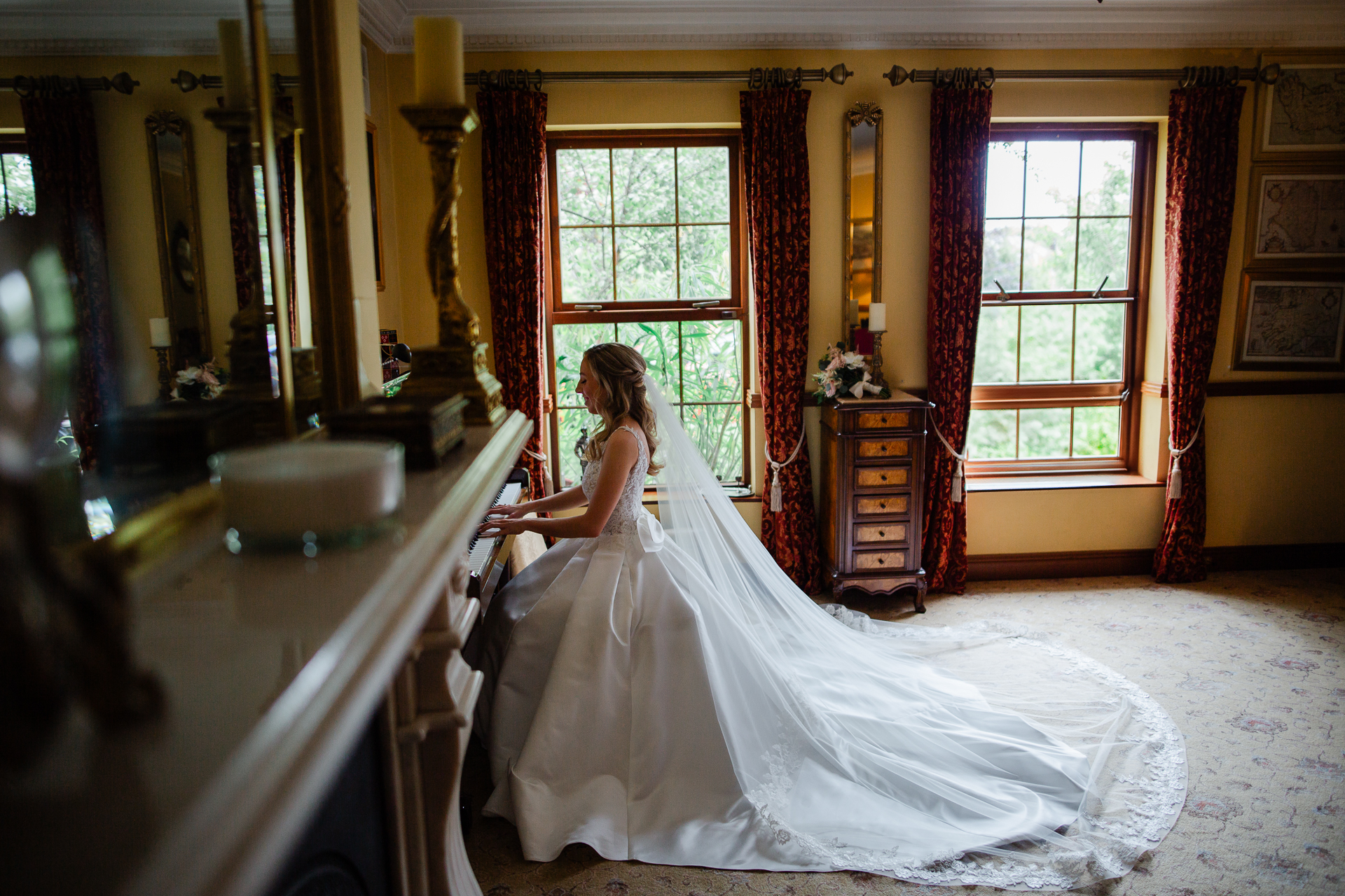 A person in a wedding dress sitting on a white bench in a room