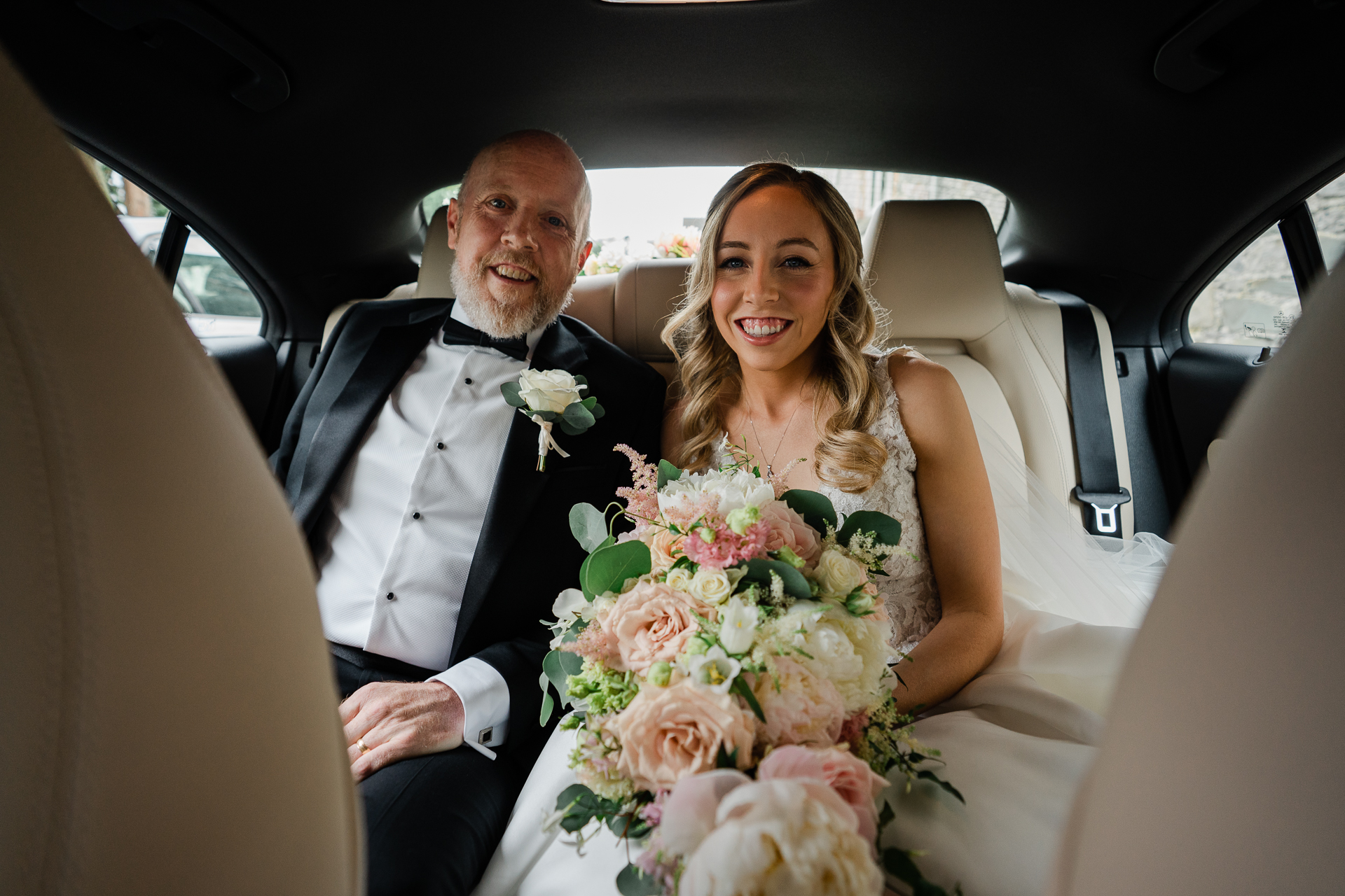 A man and woman in a car holding flowers