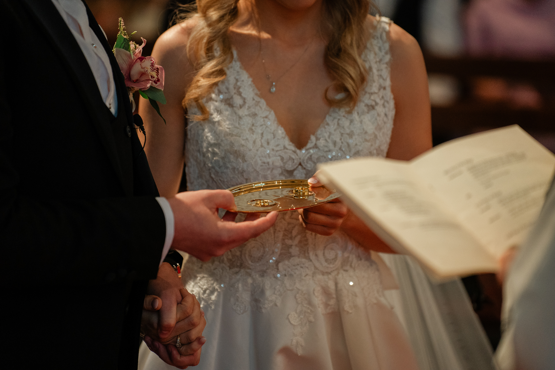 A woman in a wedding dress holding a gold ring