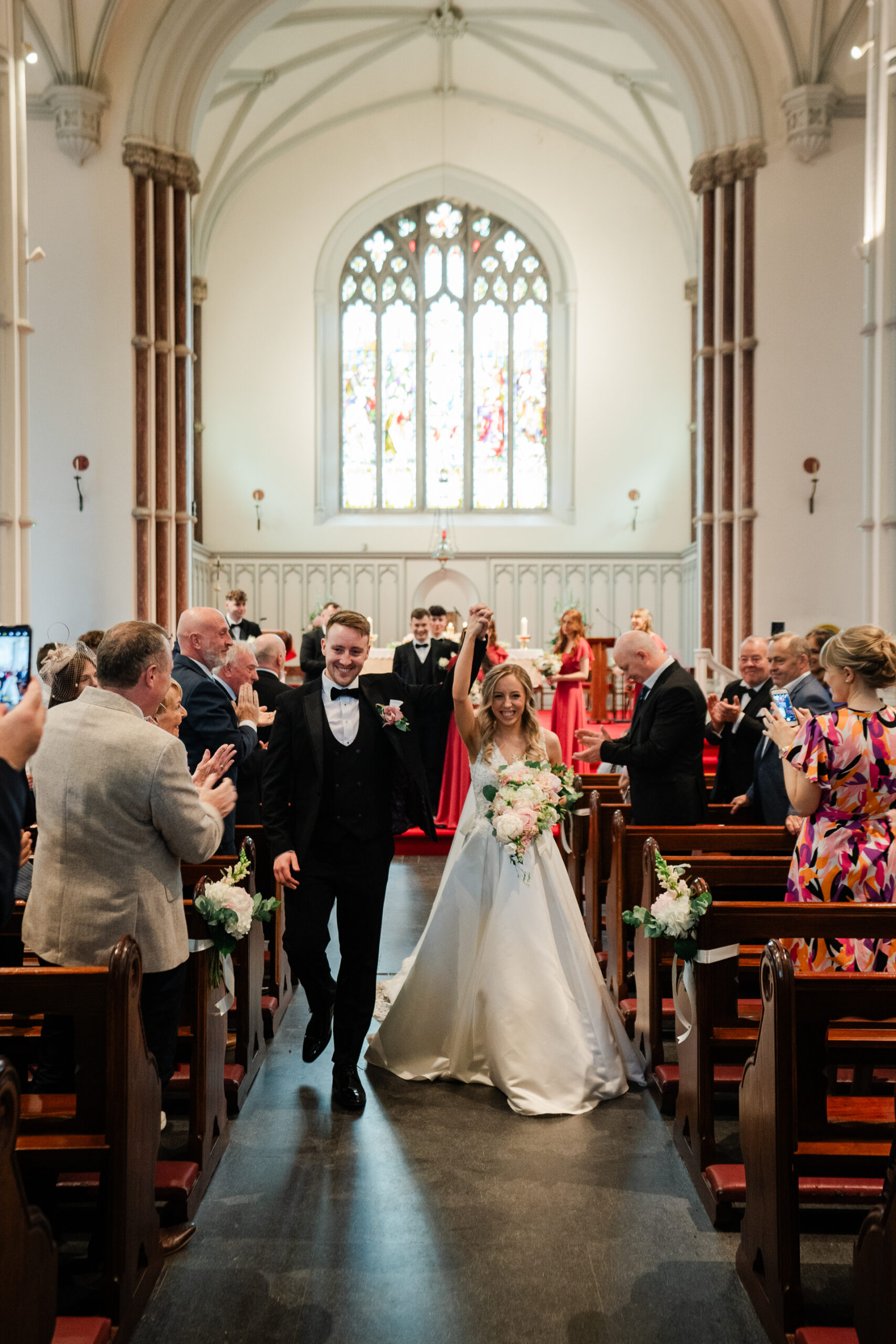 A man and woman walking down a aisle in a church