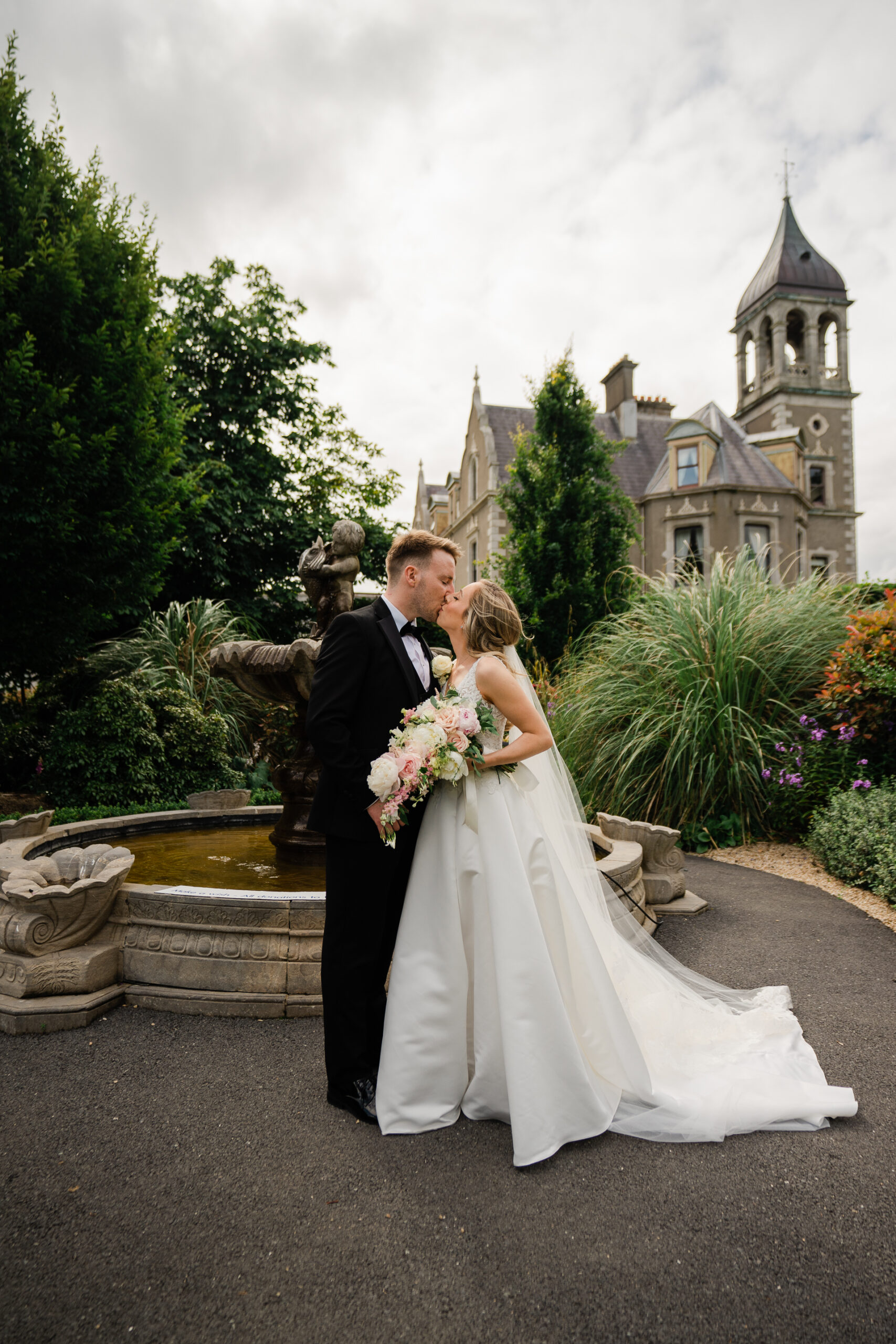 A man and woman kissing in front of a castle