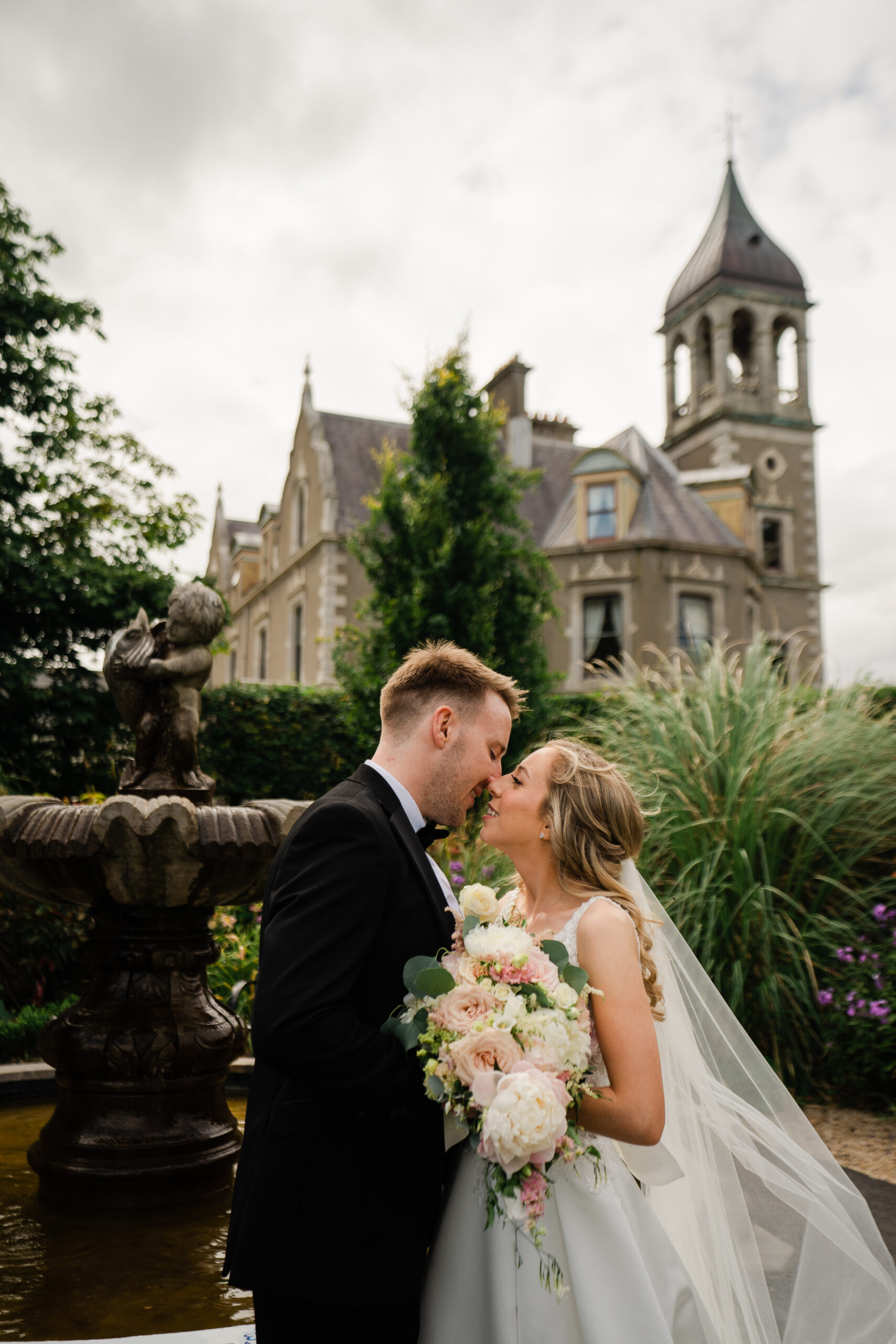 A man and woman kissing in front of a castle