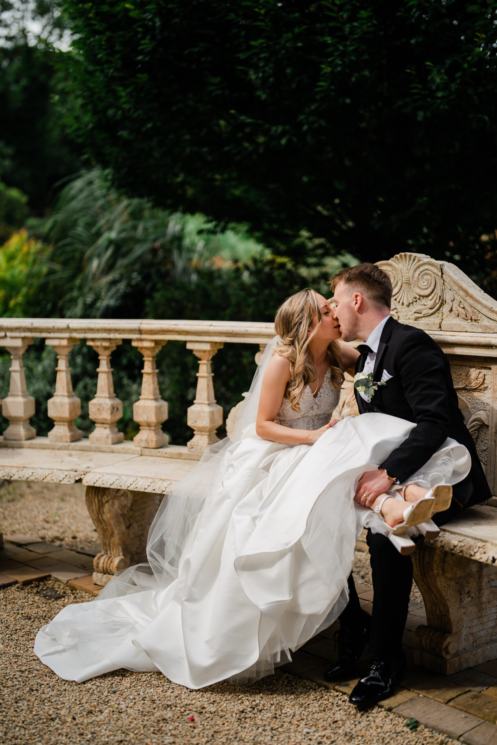 A man and woman kissing on a bench