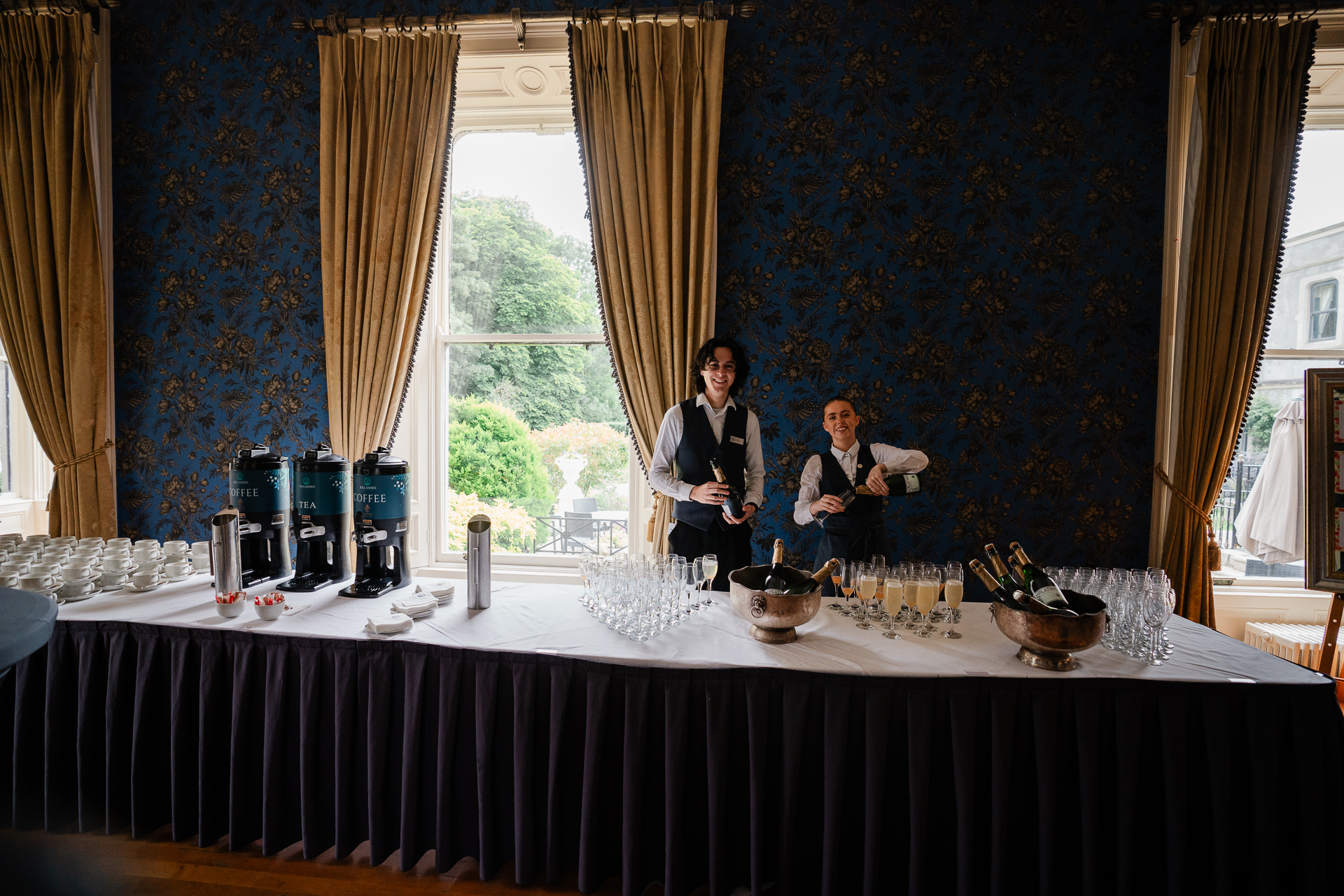 A couple of people sitting at a table with food and drinks