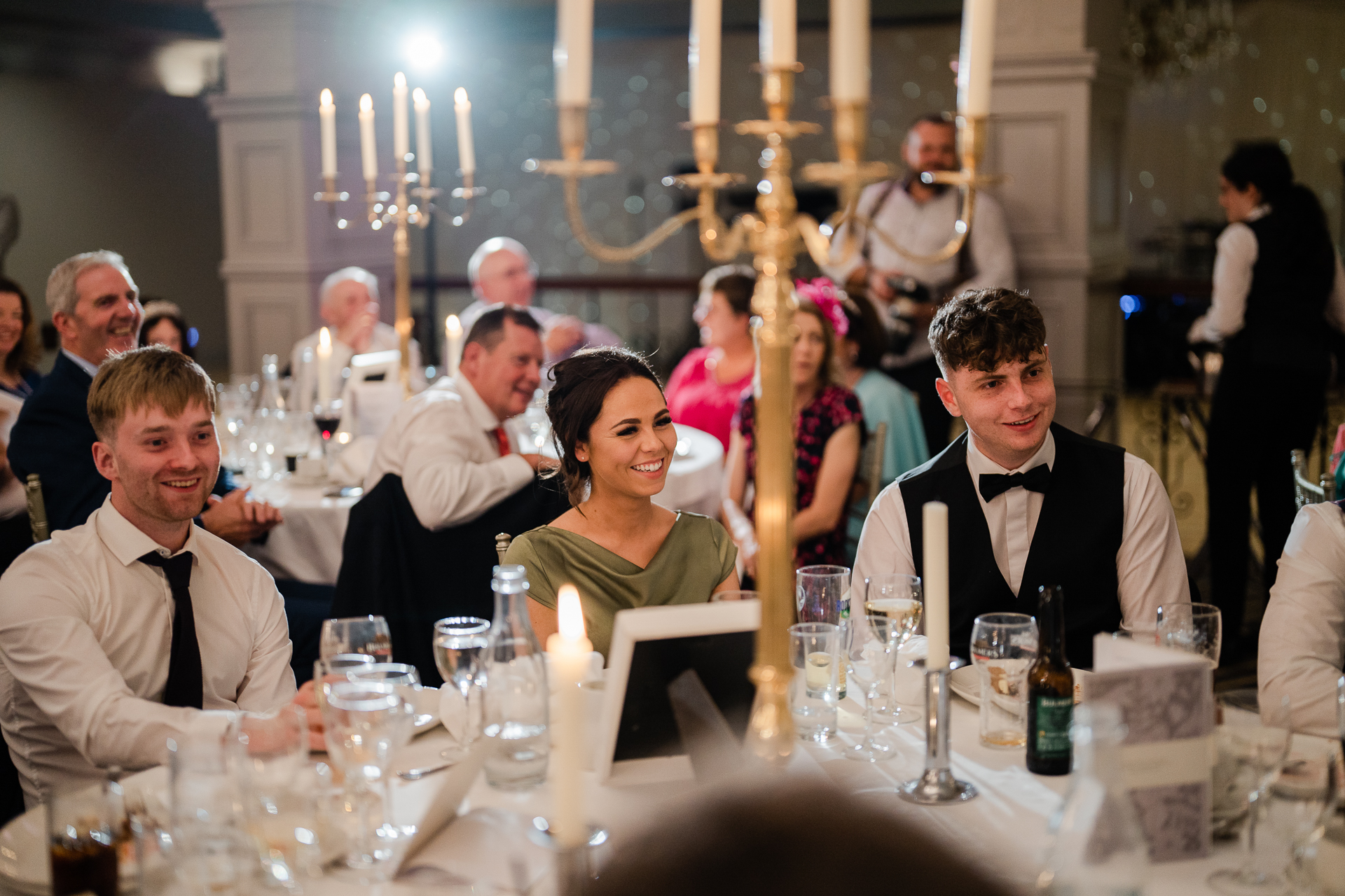 A group of people sitting at a table with candles and glasses