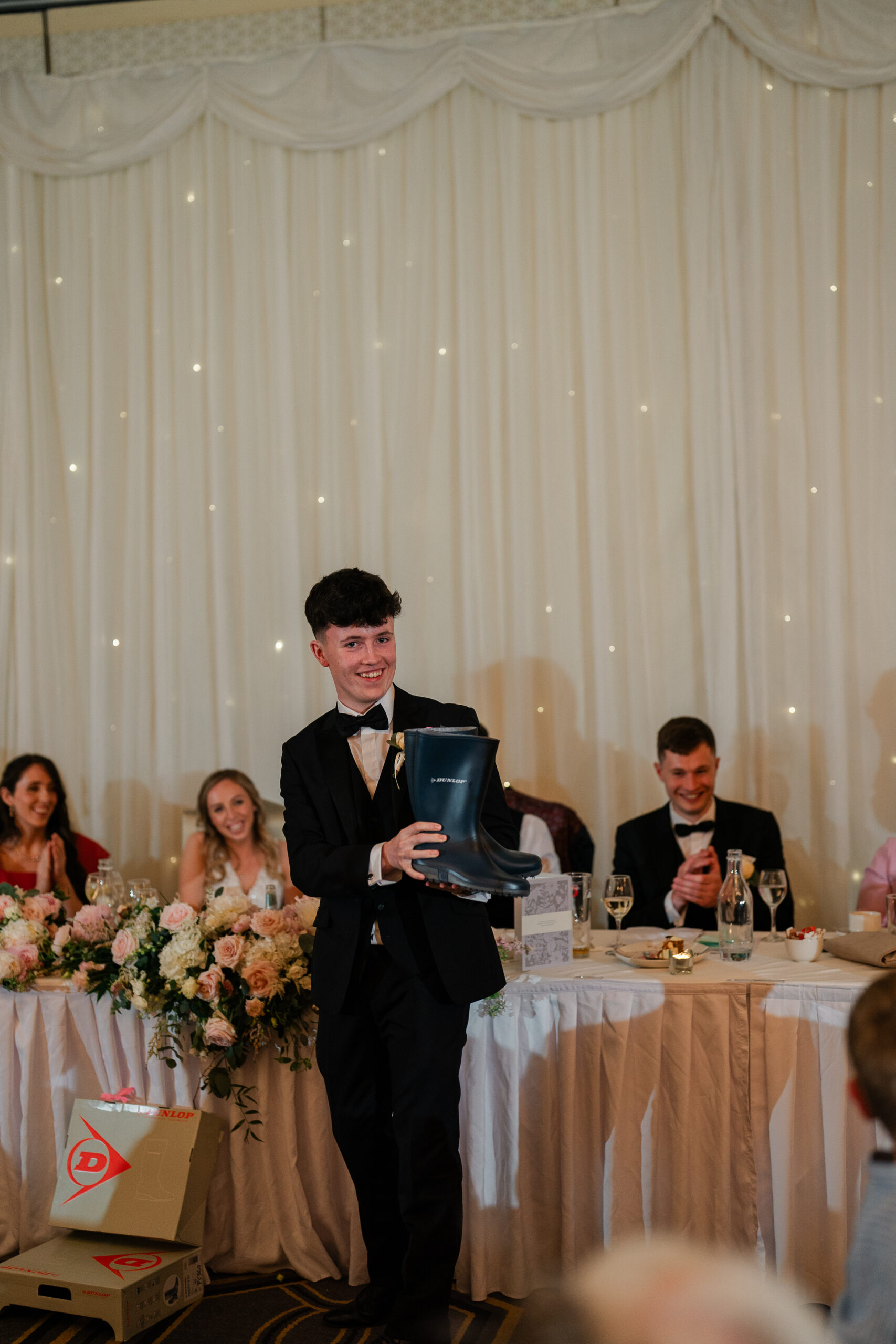 A man in a tuxedo holding a trophy