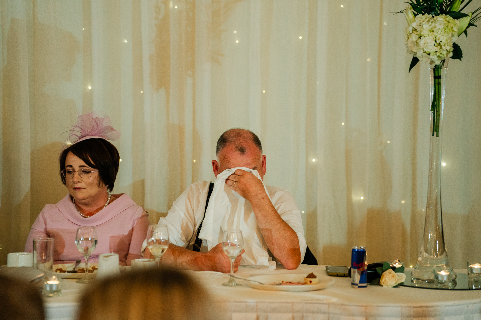 A man and a woman sitting at a table with food and drinks