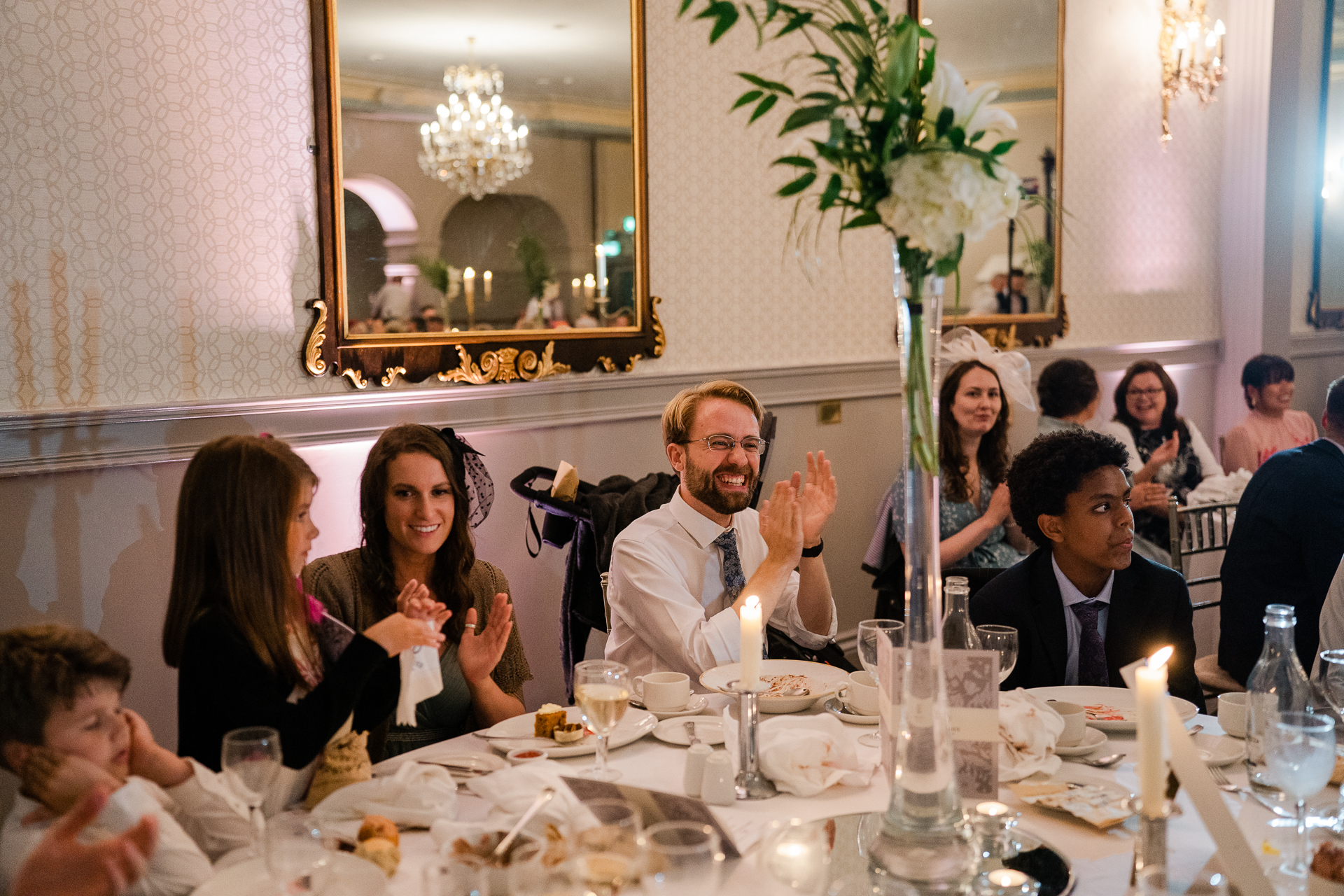 A group of people sitting at a table with candles