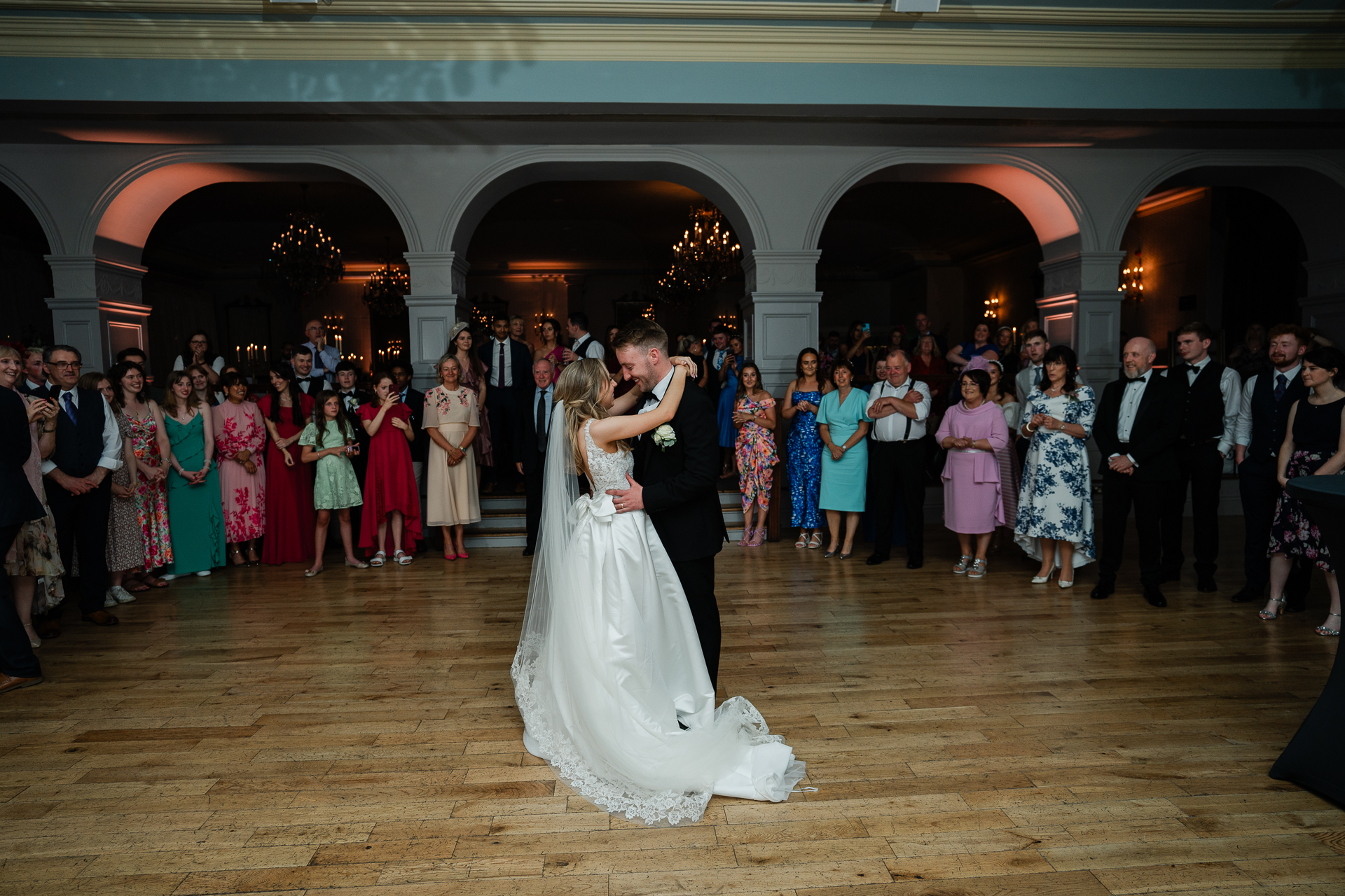 A man and woman dancing in a room with a large group of people