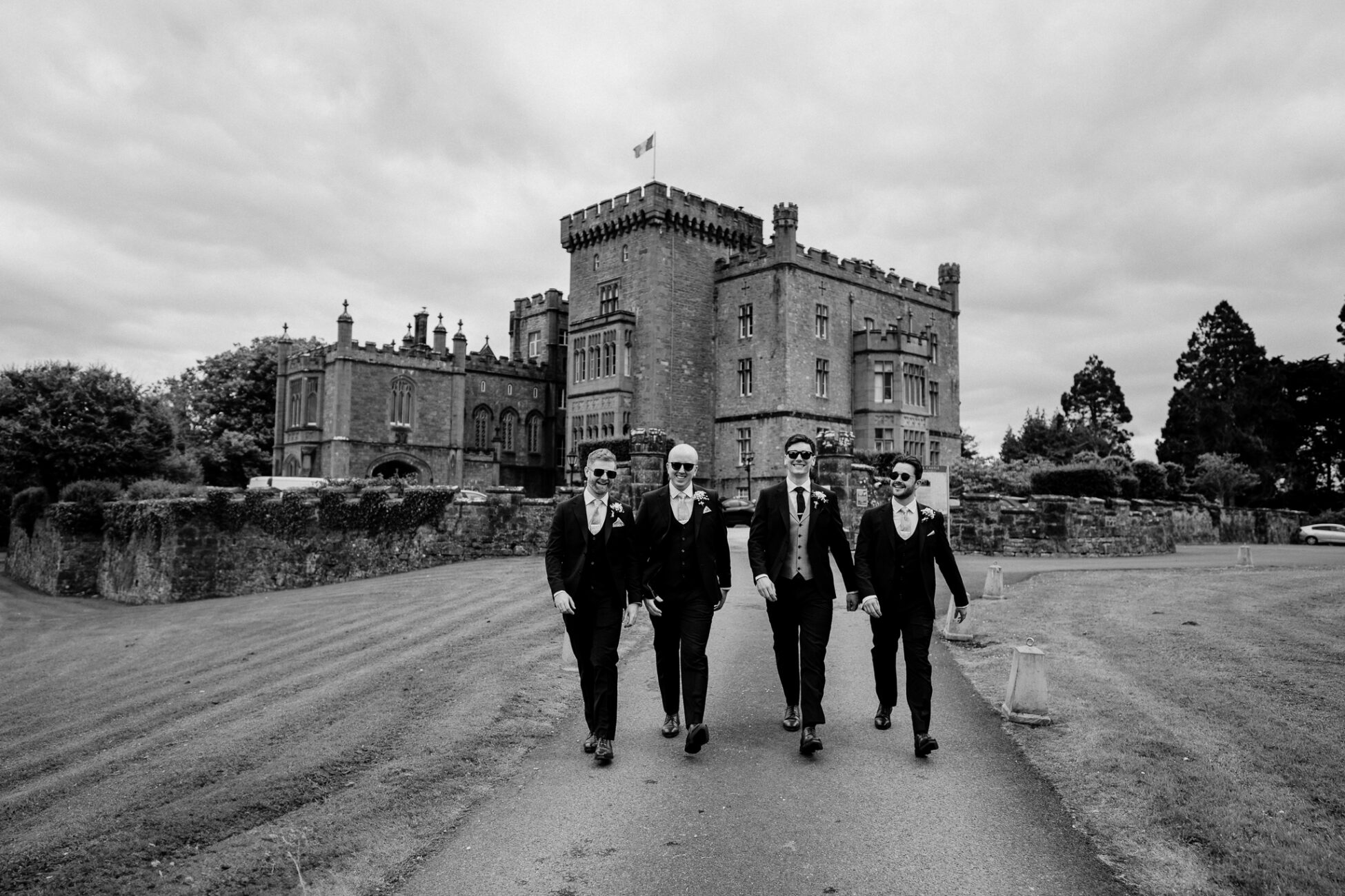 A group of men in suits walking in front of a castle