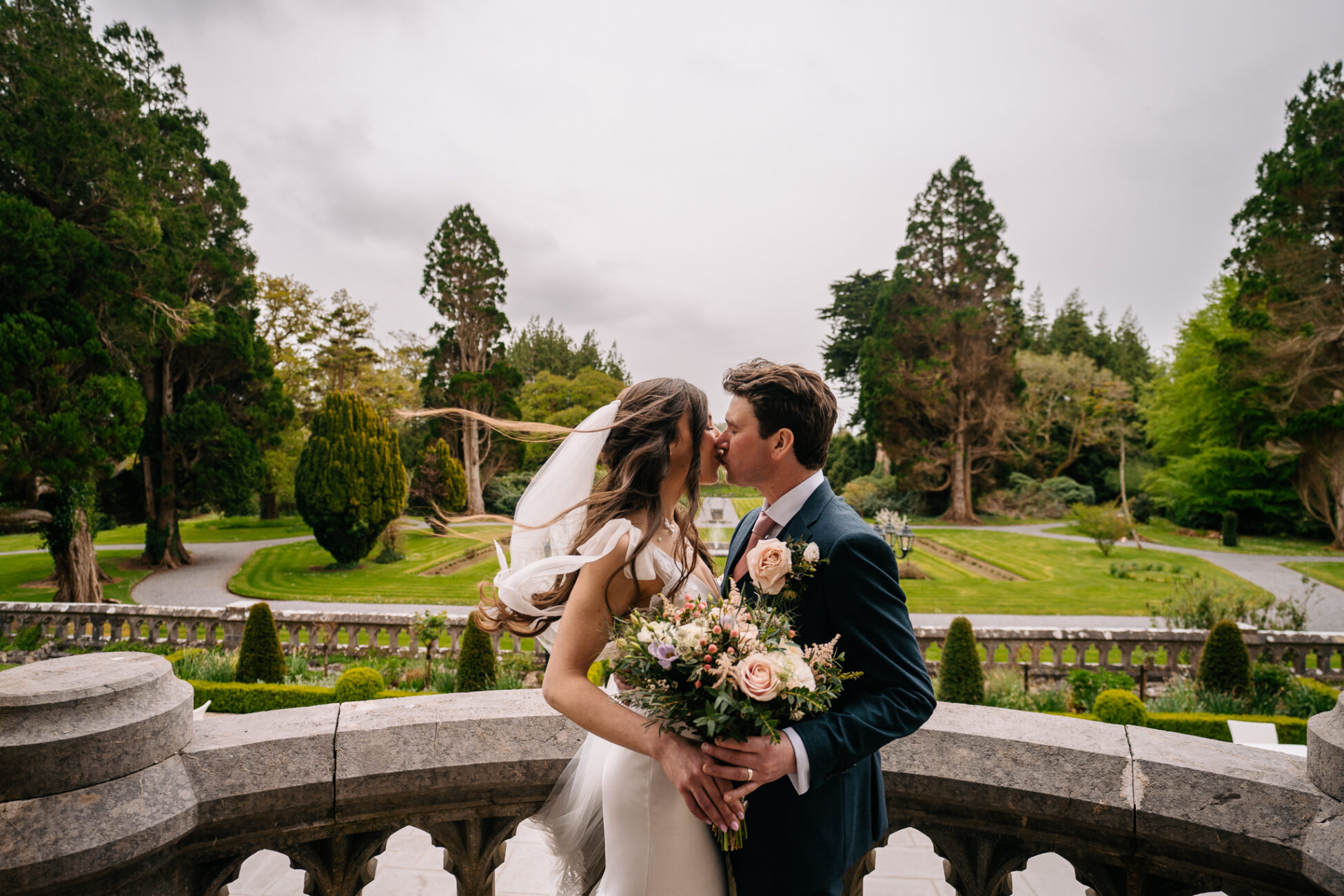 A man and woman kissing on a bridge