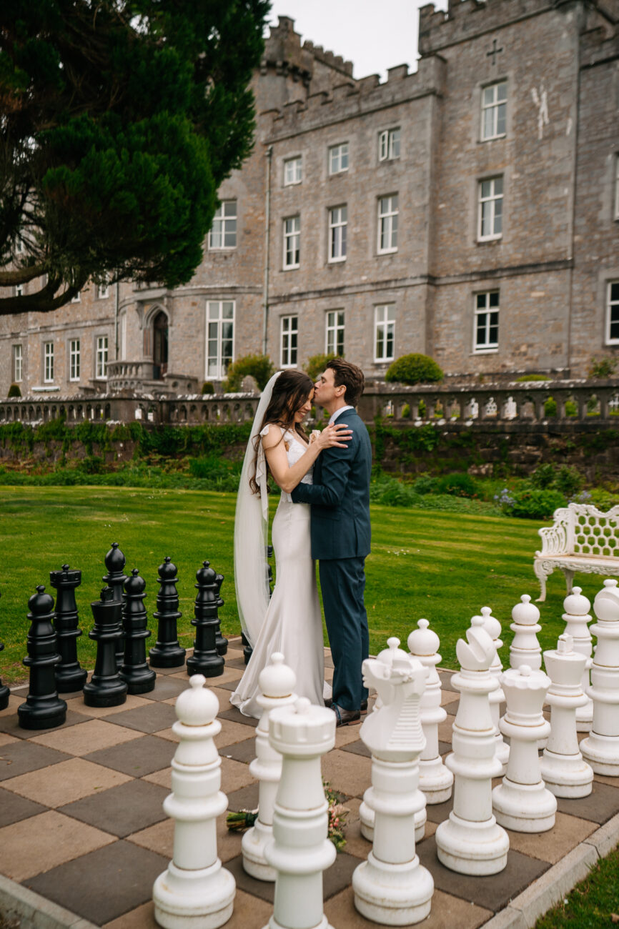 A man and woman kissing in front of a building