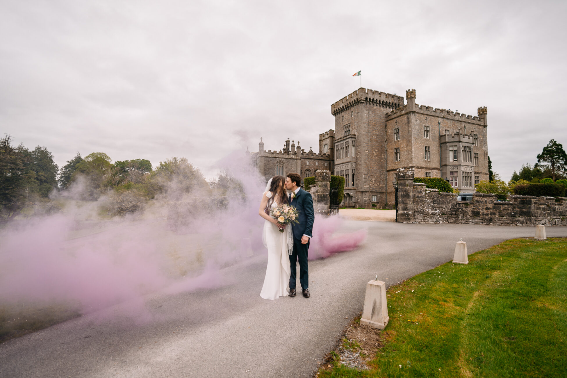 A man and woman kissing in front of a castle