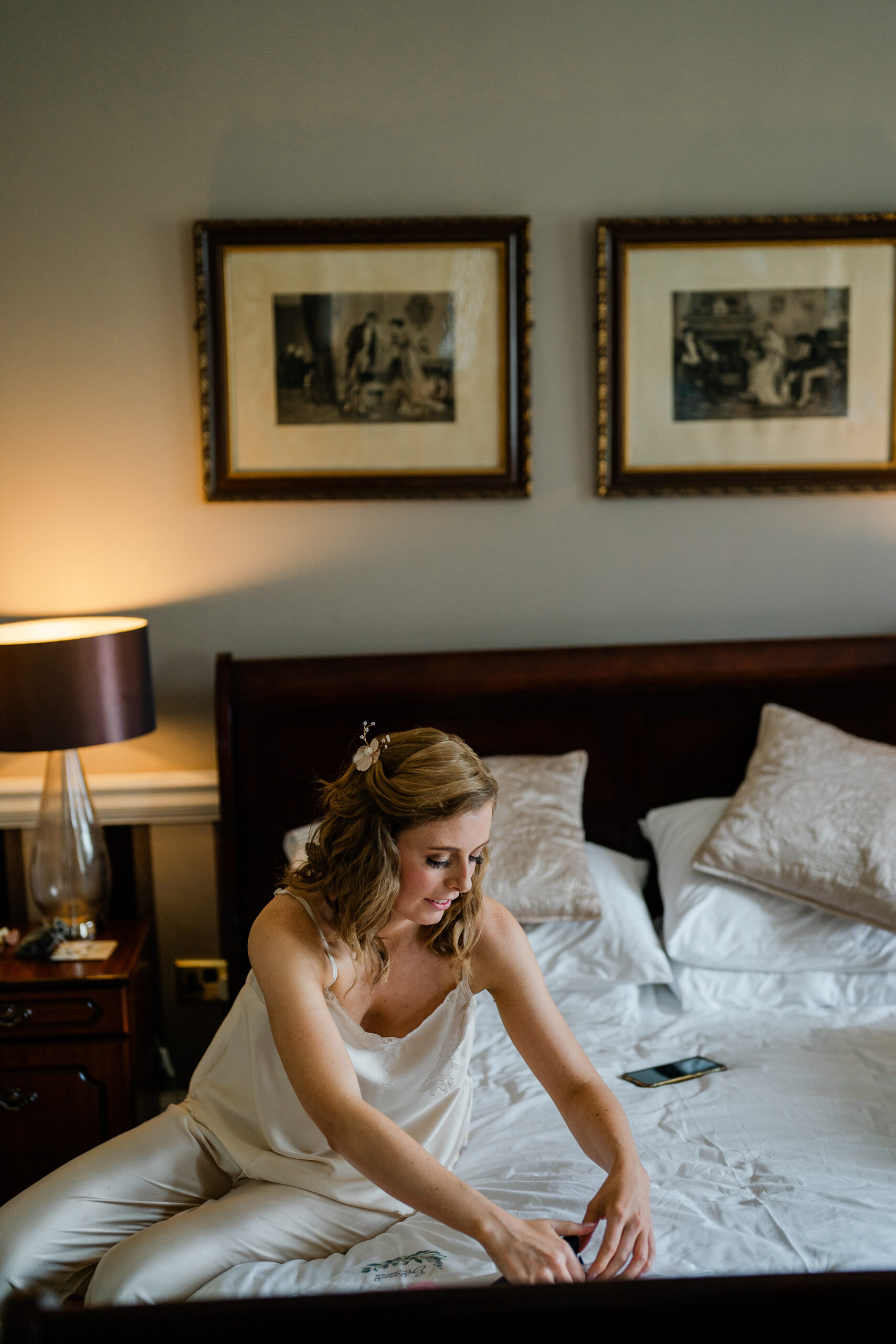 A woman in a wedding dress sitting on a bed