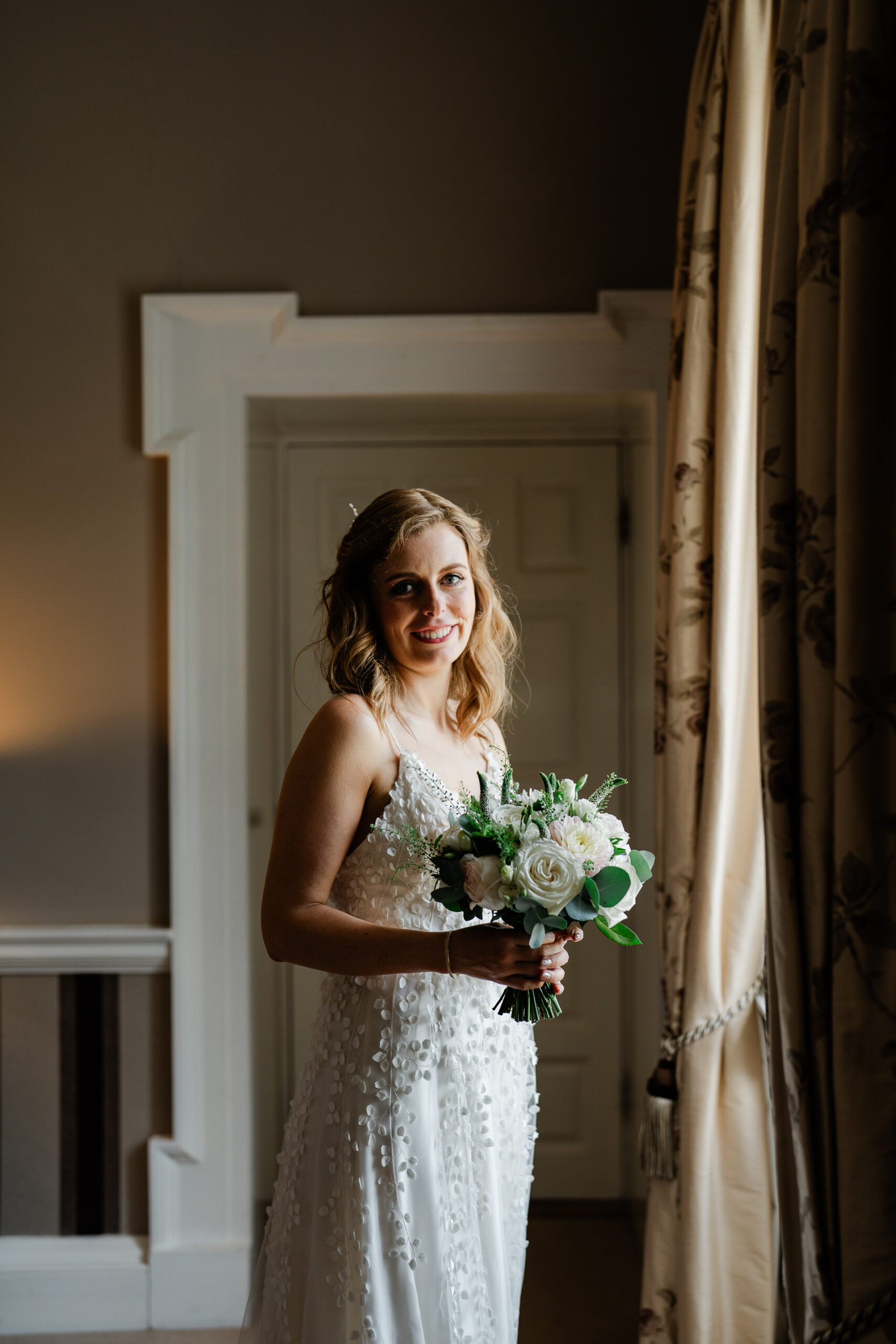 A woman in a wedding dress holding a bouquet of flowers