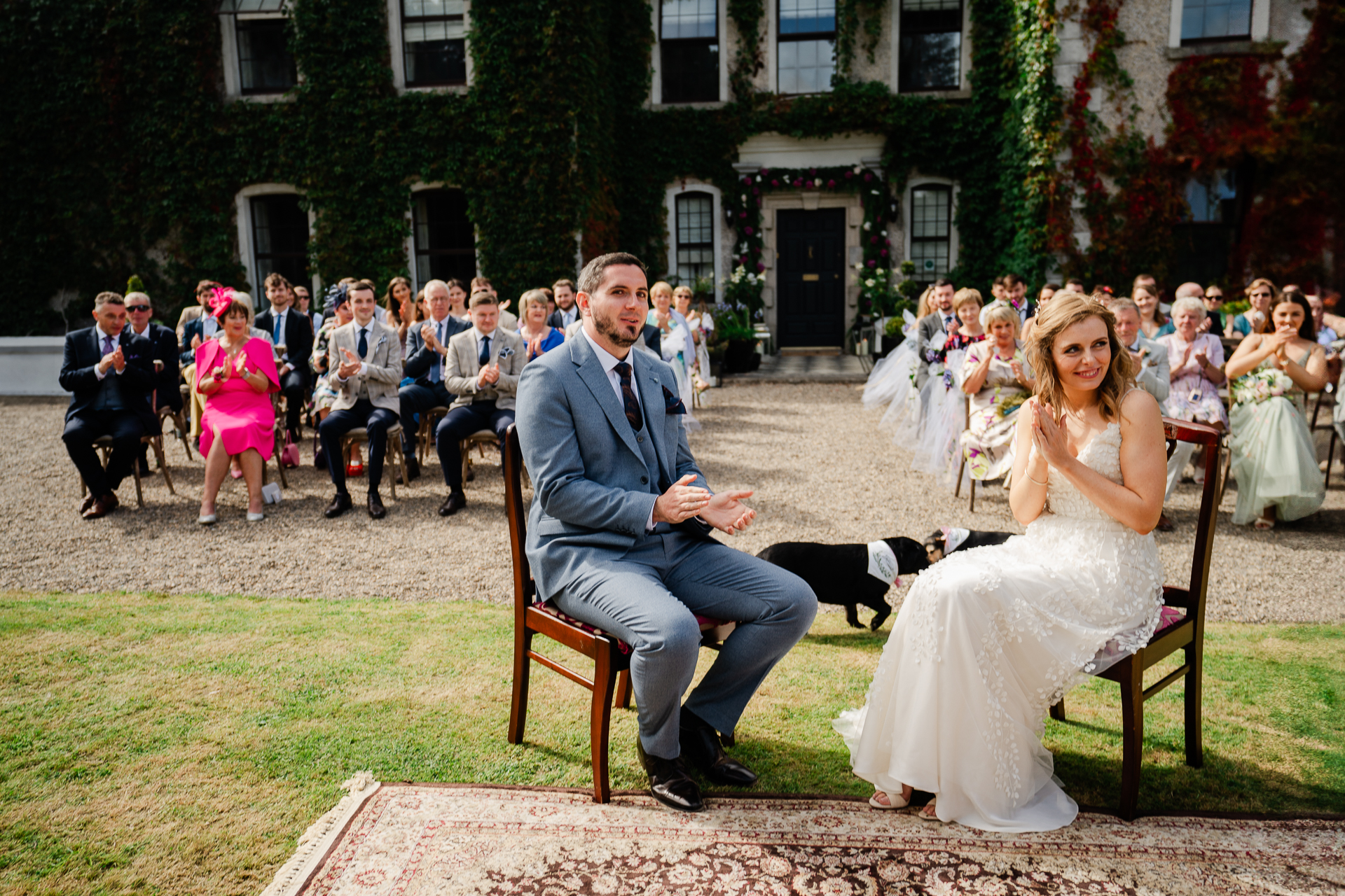 A man and woman sitting on a bench in front of a crowd