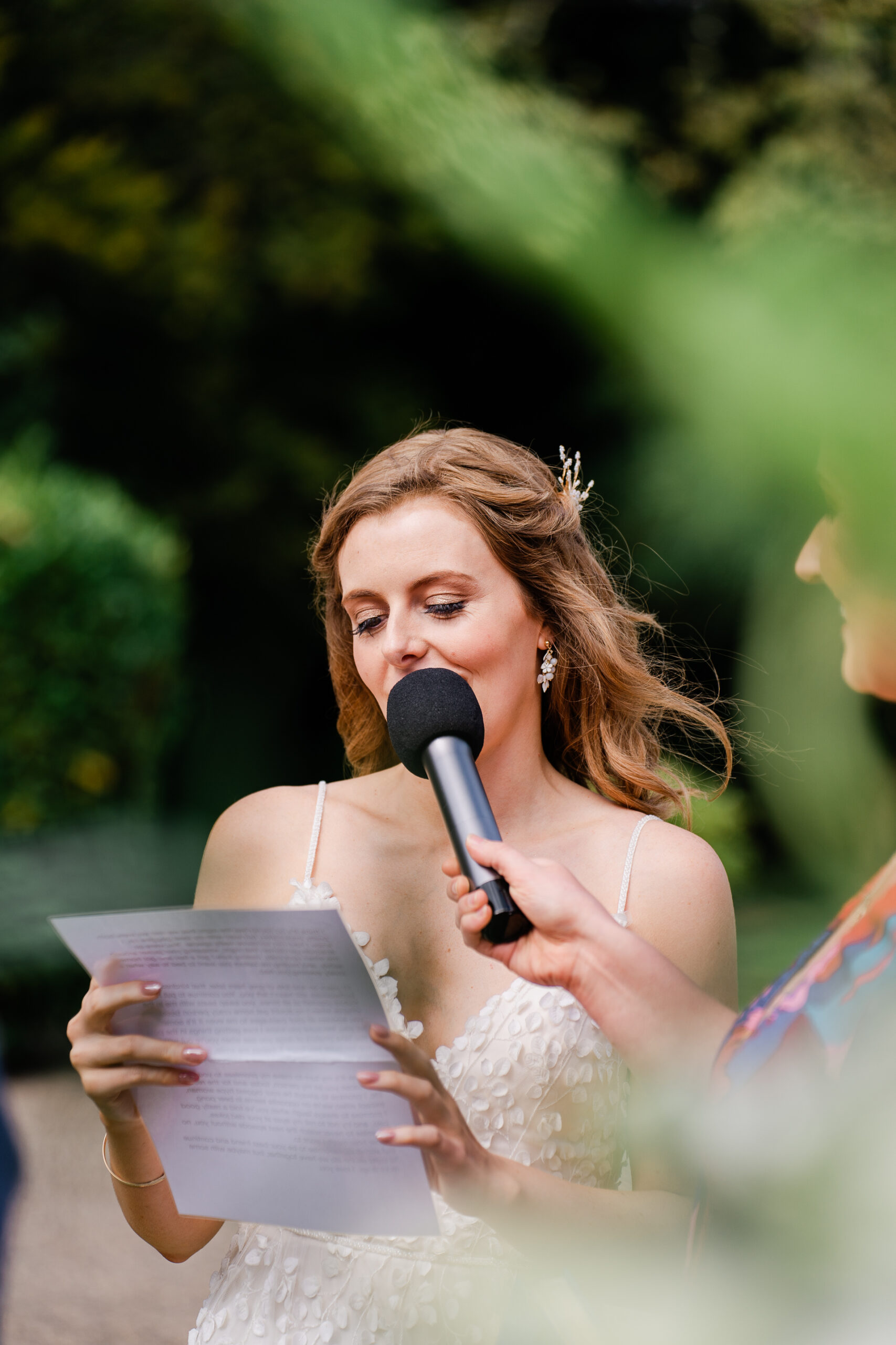 A person in a white dress holding a microphone