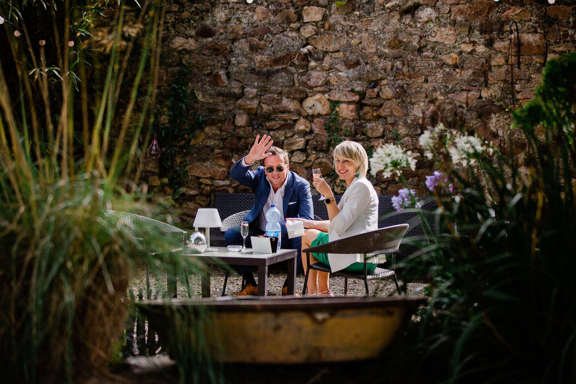 A man and woman sitting at a table with a laptop and a fountain