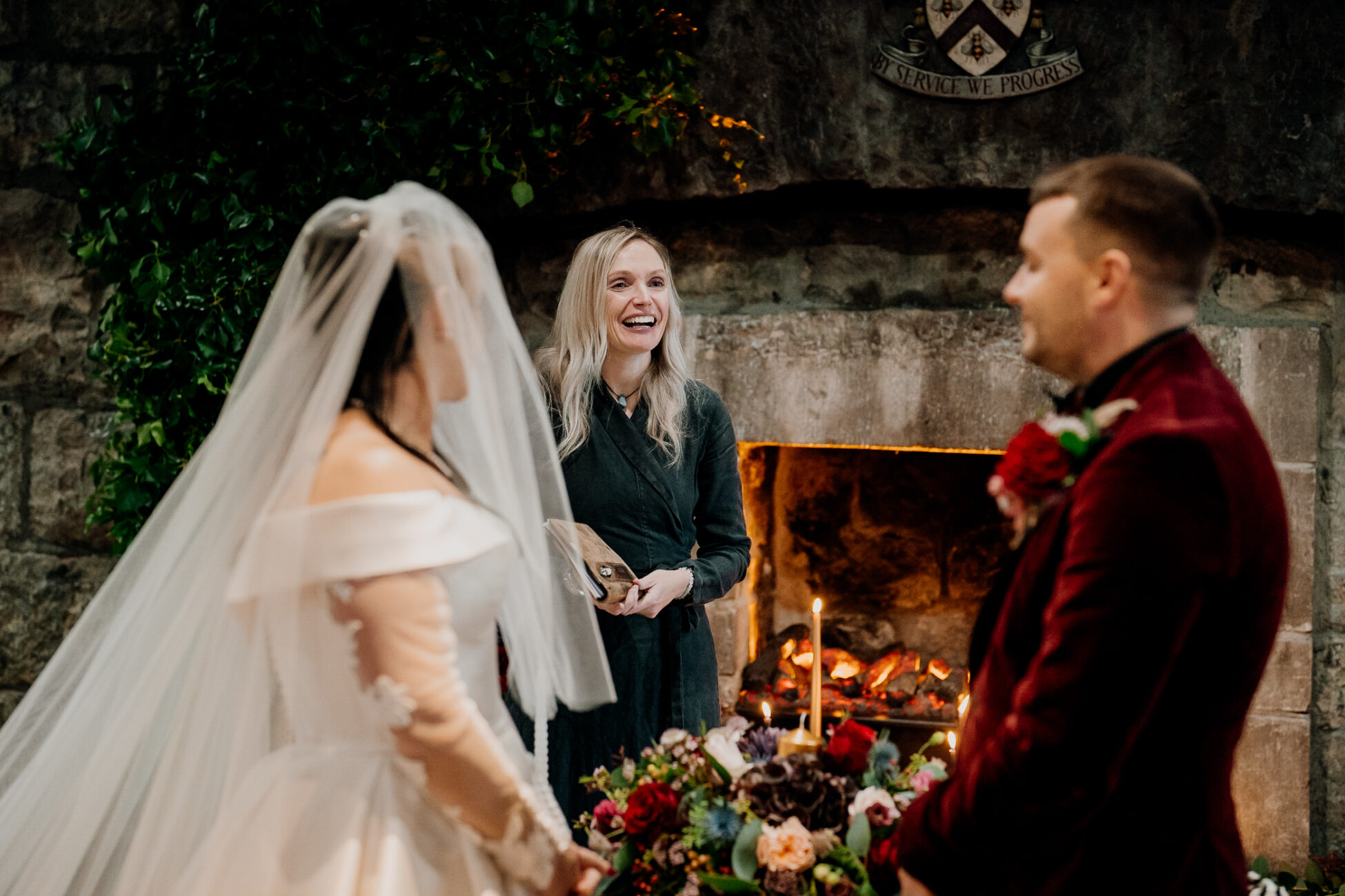 A bride and groom in front of a fireplace