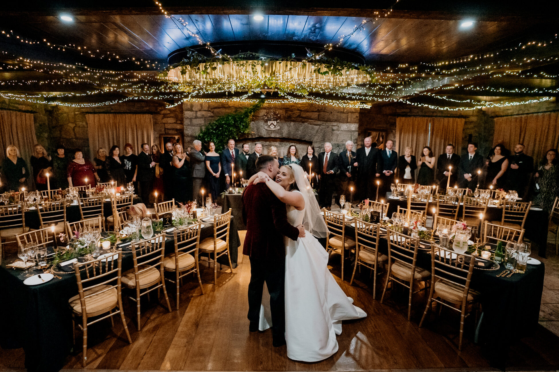 A man and woman kissing in a room full of people