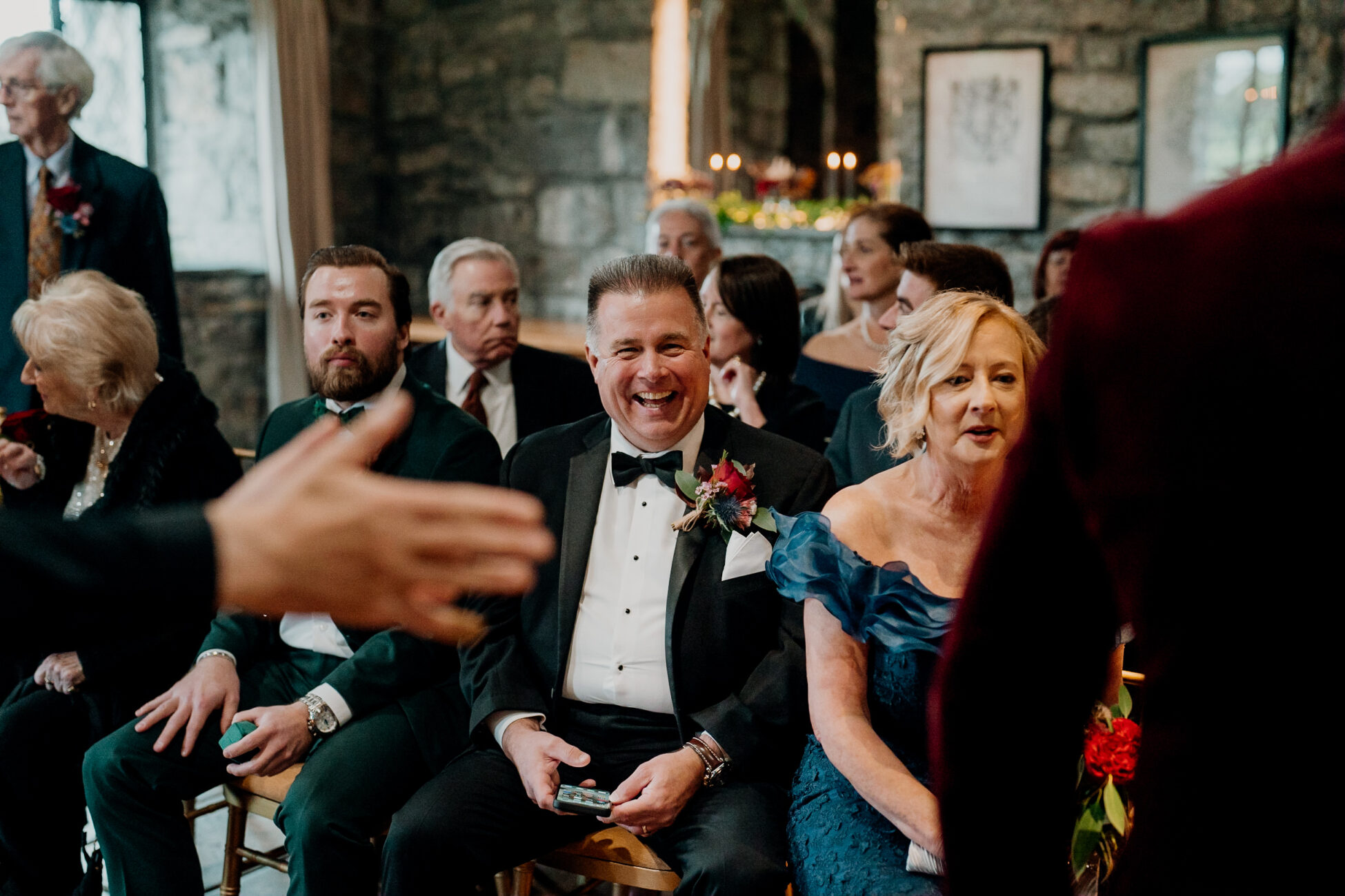 A man in a tuxedo sitting with a woman in a dress