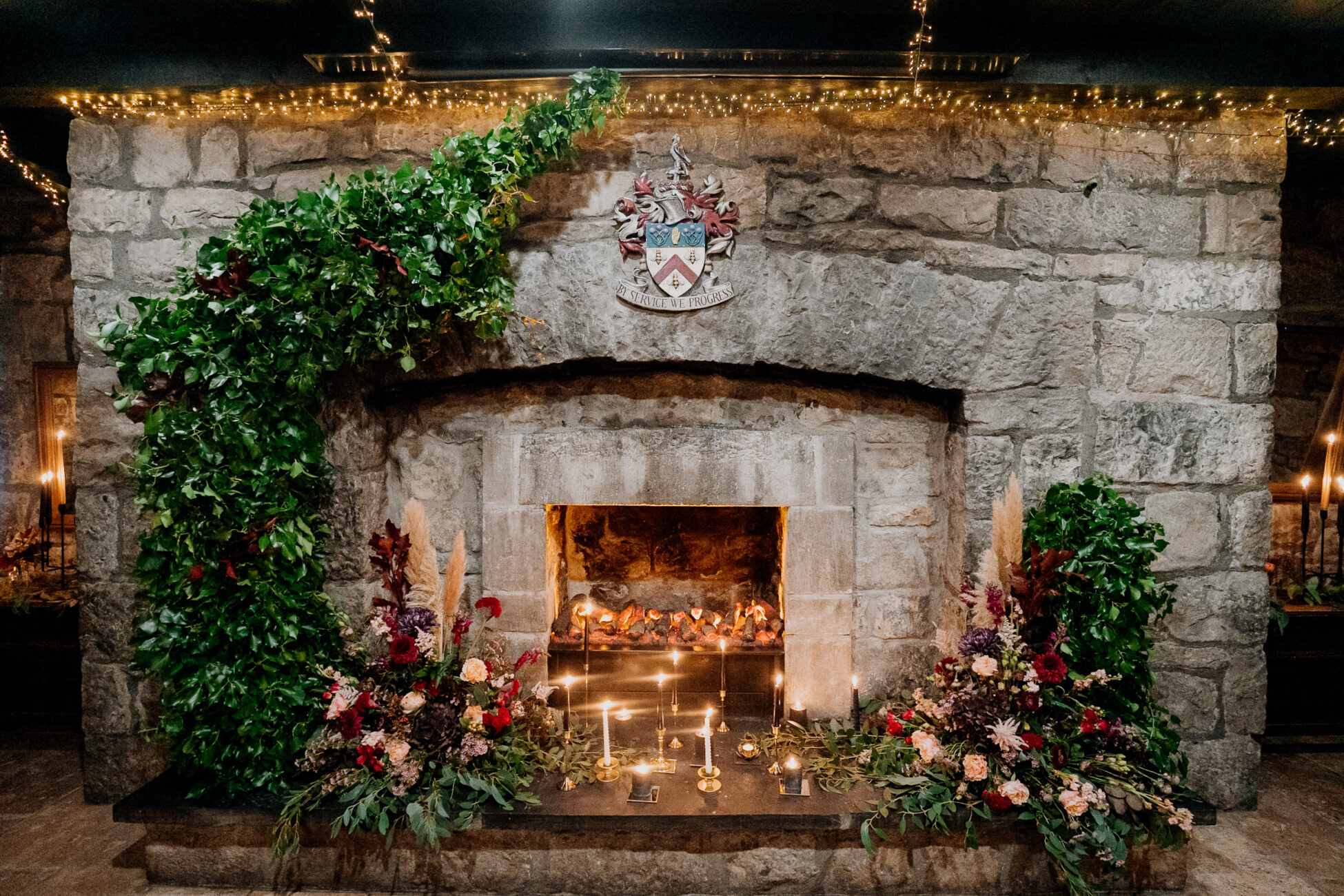 A fireplace with flowers in front of it