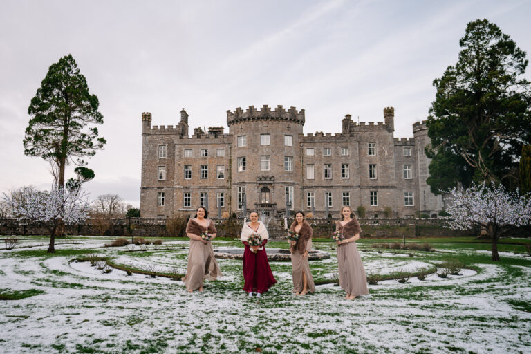 A group of people in dresses standing in front of a large building