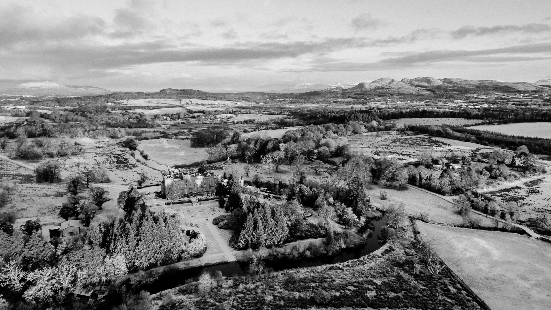 A black and white photo of a town in the middle of a snowy landscape