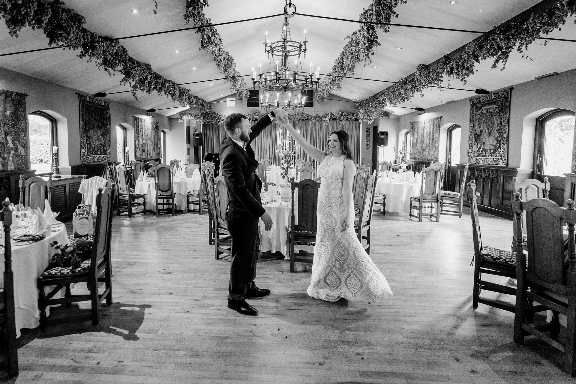 A man and woman dancing in a room with tables and chairs