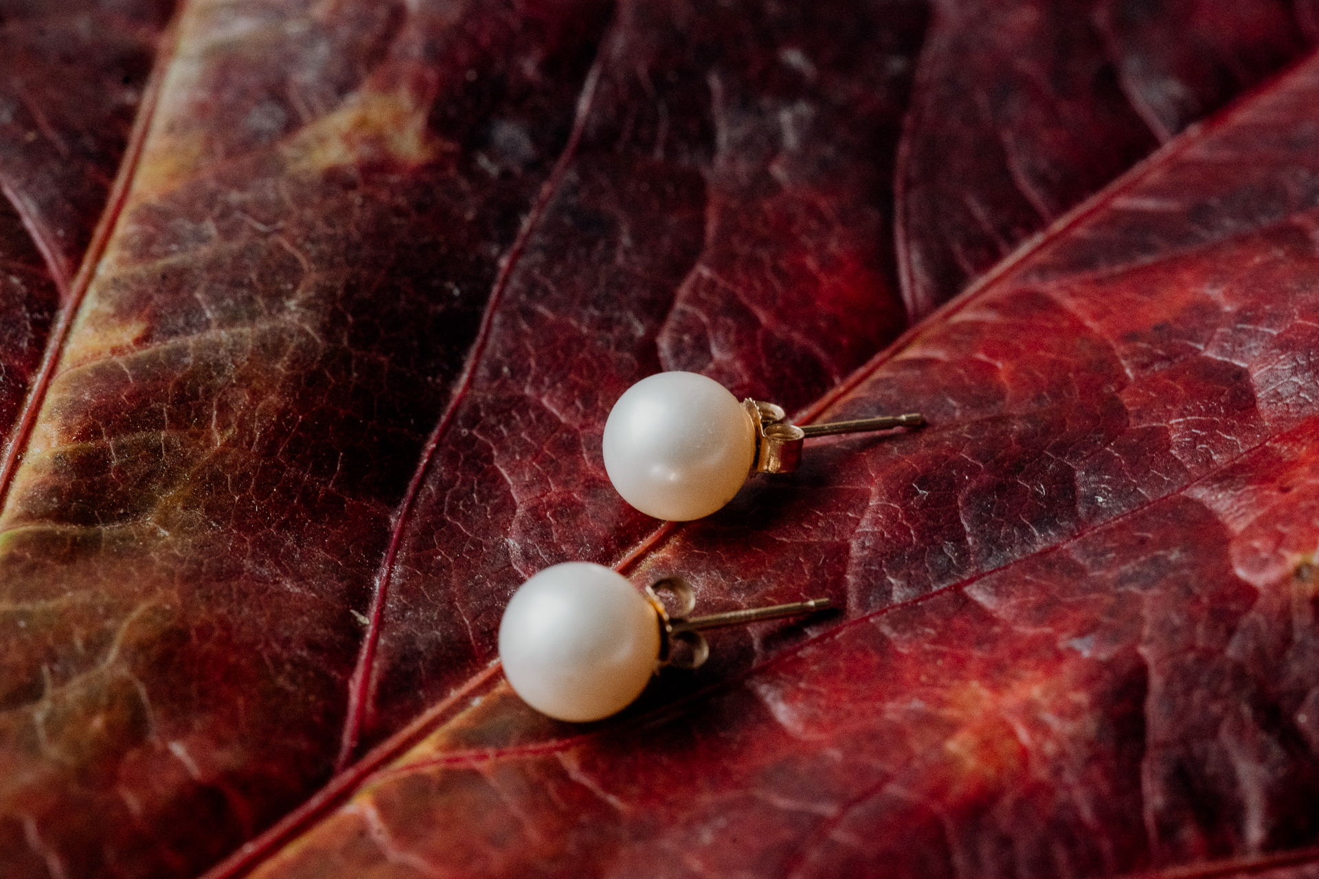 A pair of earrings on a red surface