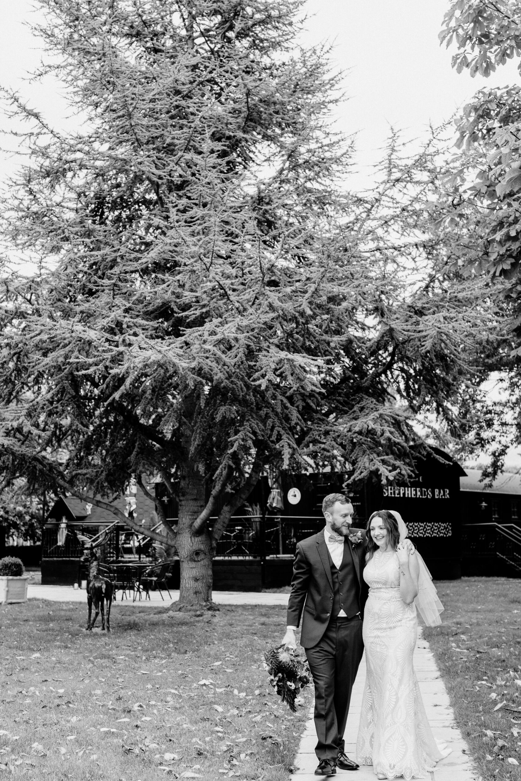 A man and woman posing for a picture next to a large tree