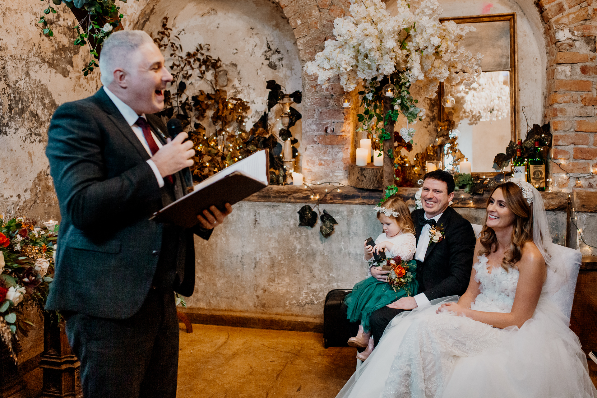 A man in a suit and a woman in a dress holding a book