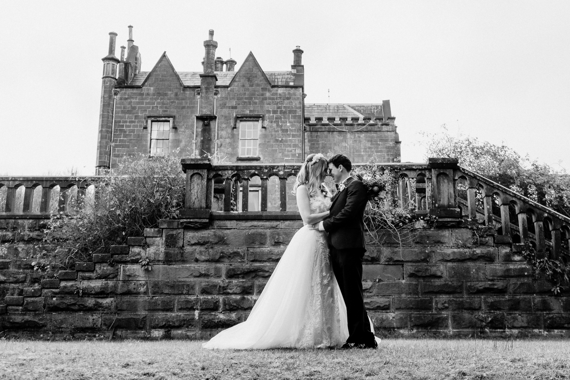 A man and woman kissing in front of a house