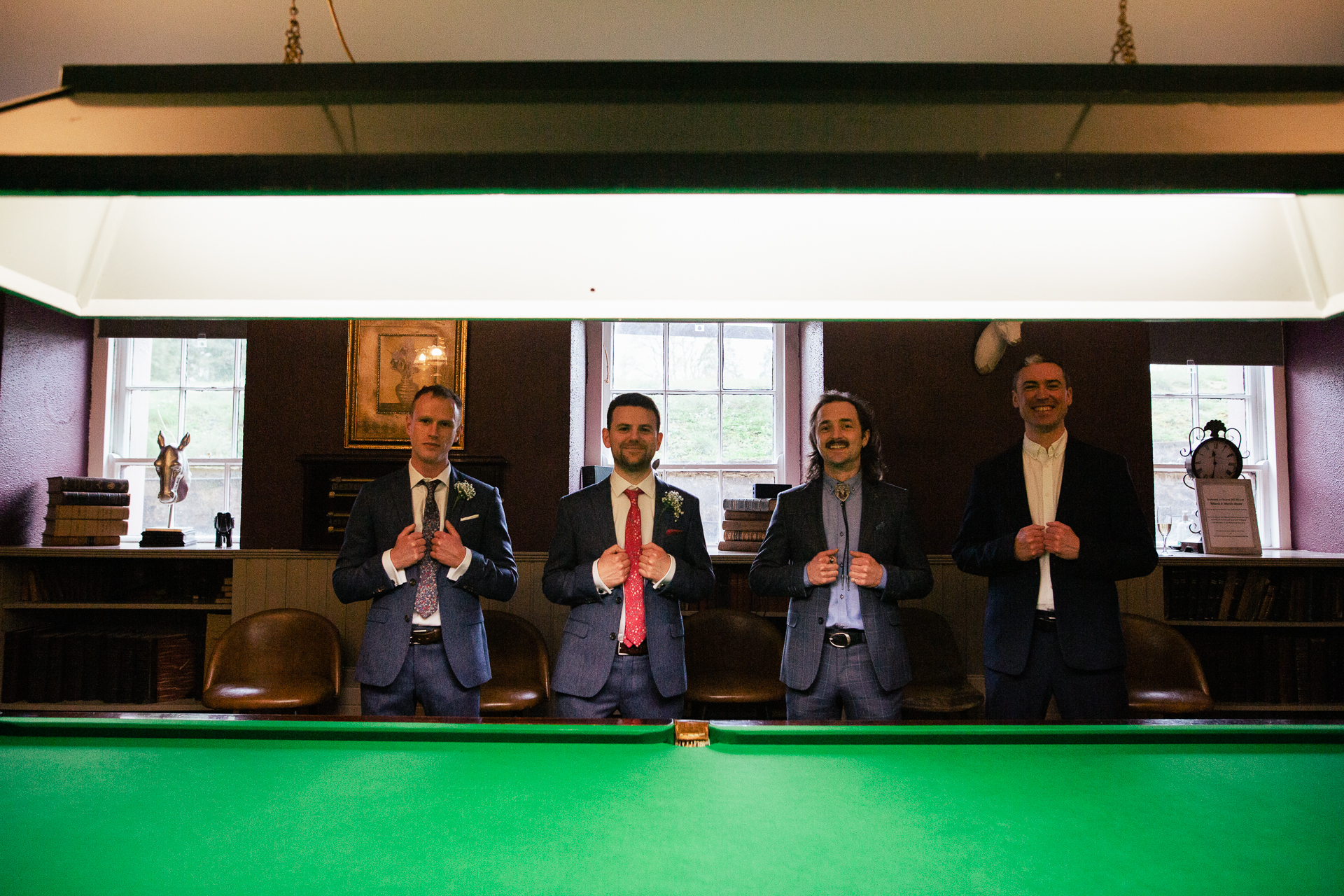 A group of people standing around a pool table