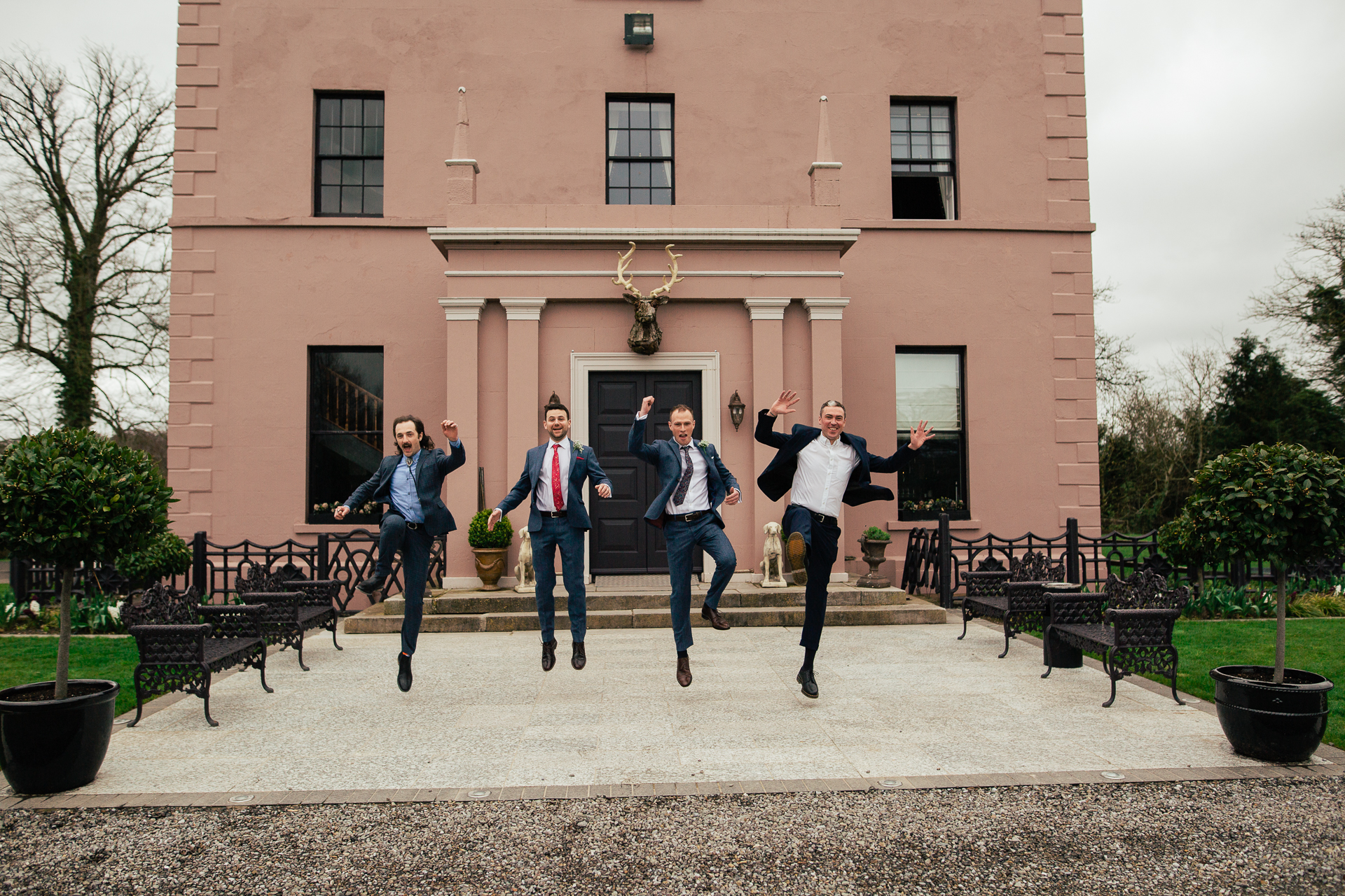 A group of people jumping in the air in front of a building