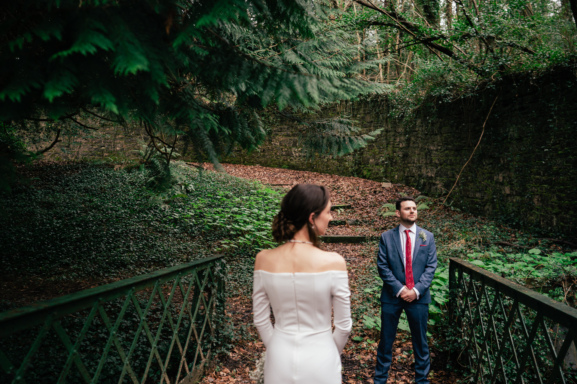 A man and woman walking on a path in a forest