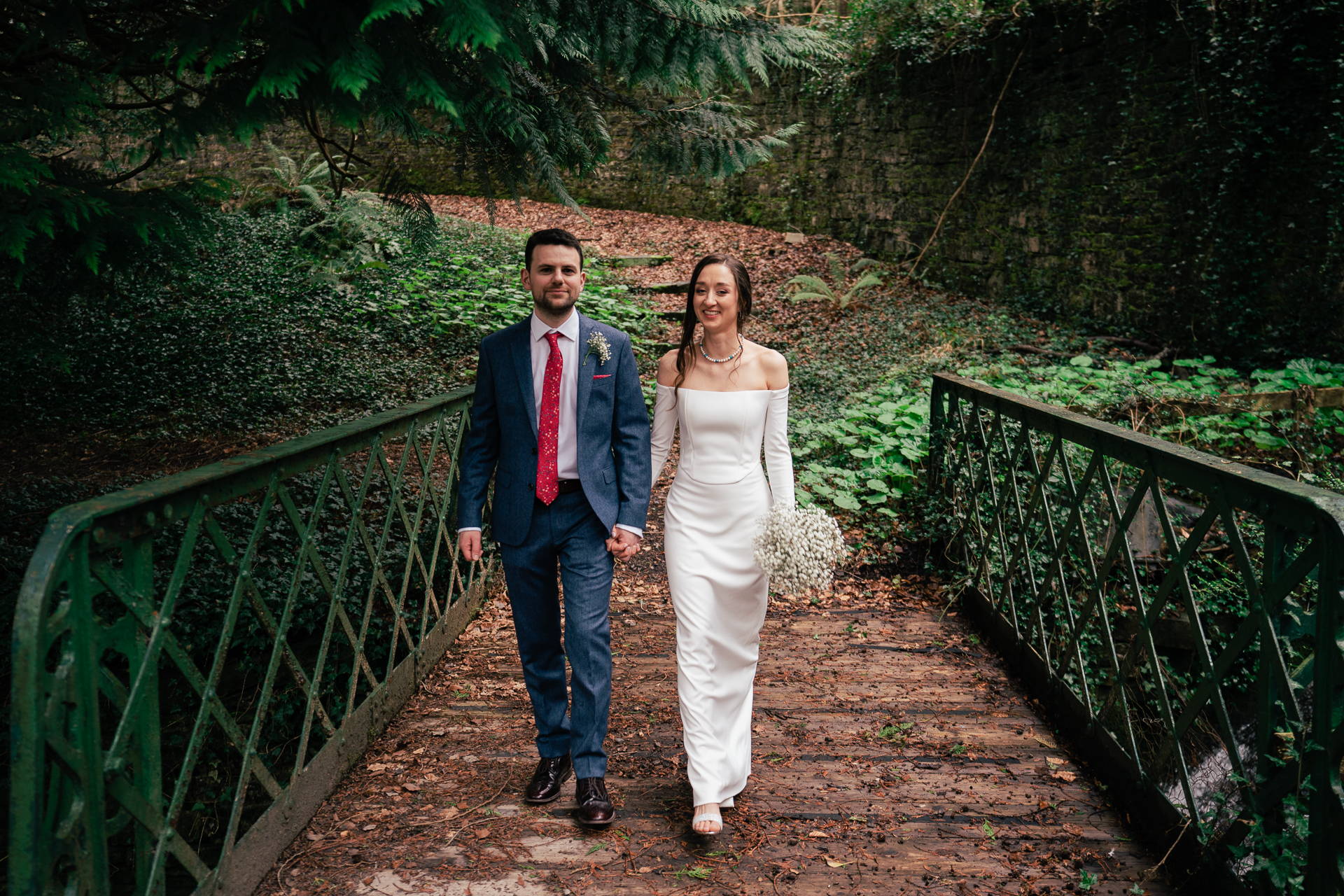 A man and woman posing for a picture on a bridge