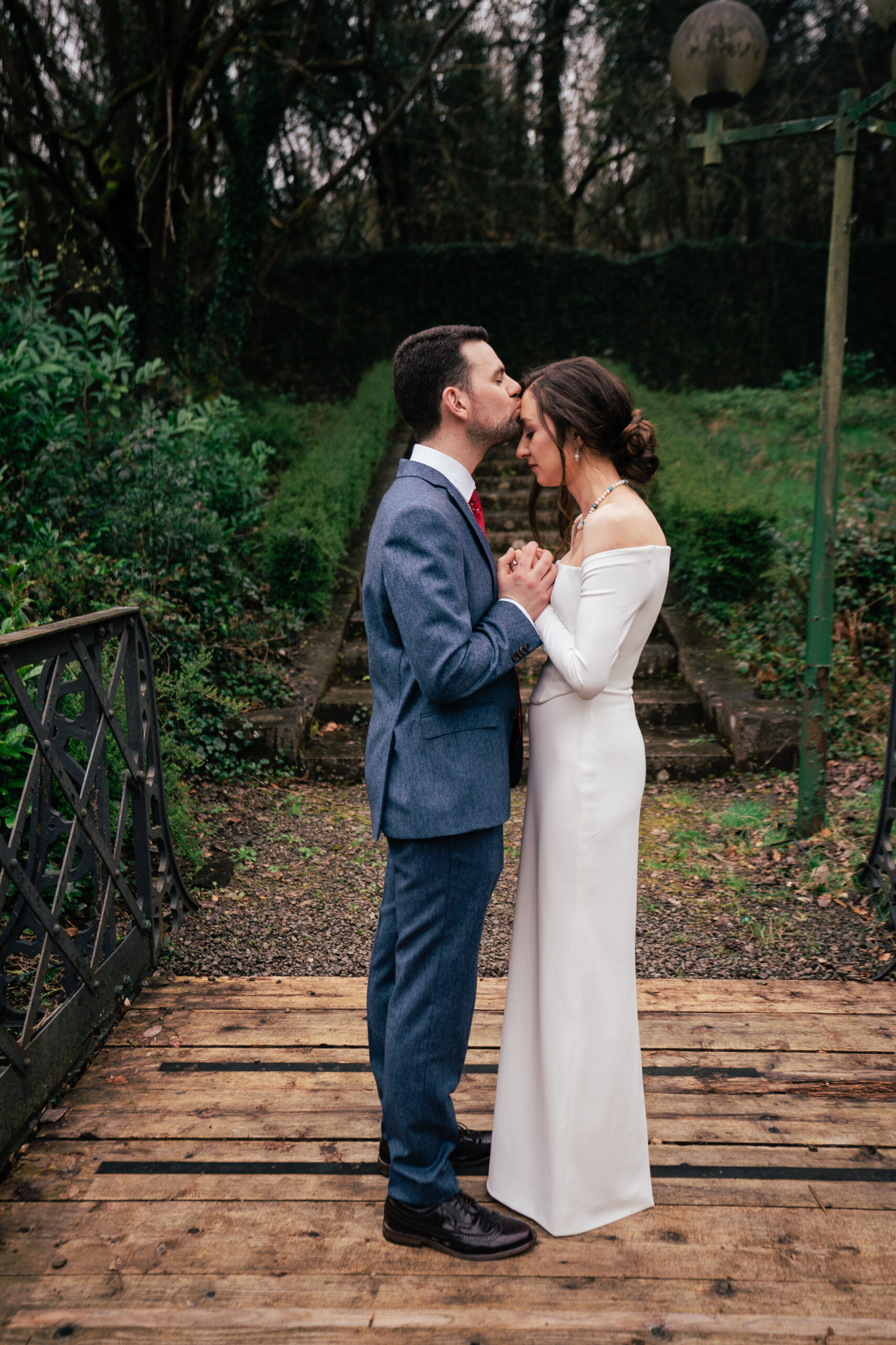 A man and woman kissing on a bridge