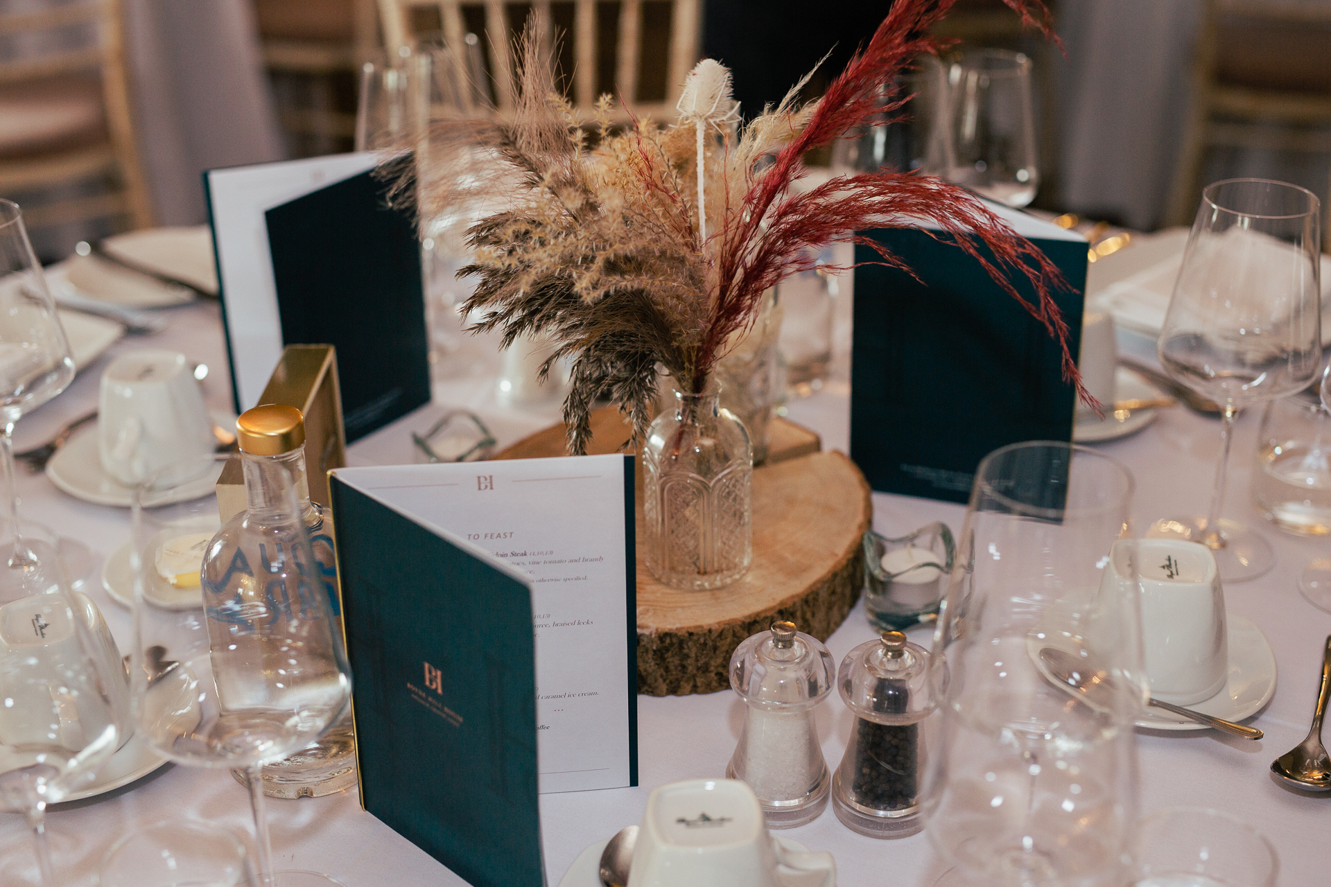 A table with a vase of flowers and glasses