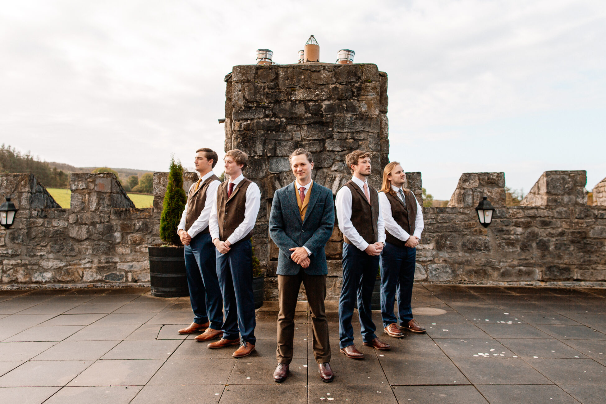 A group of people posing for a photo in front of a stone building