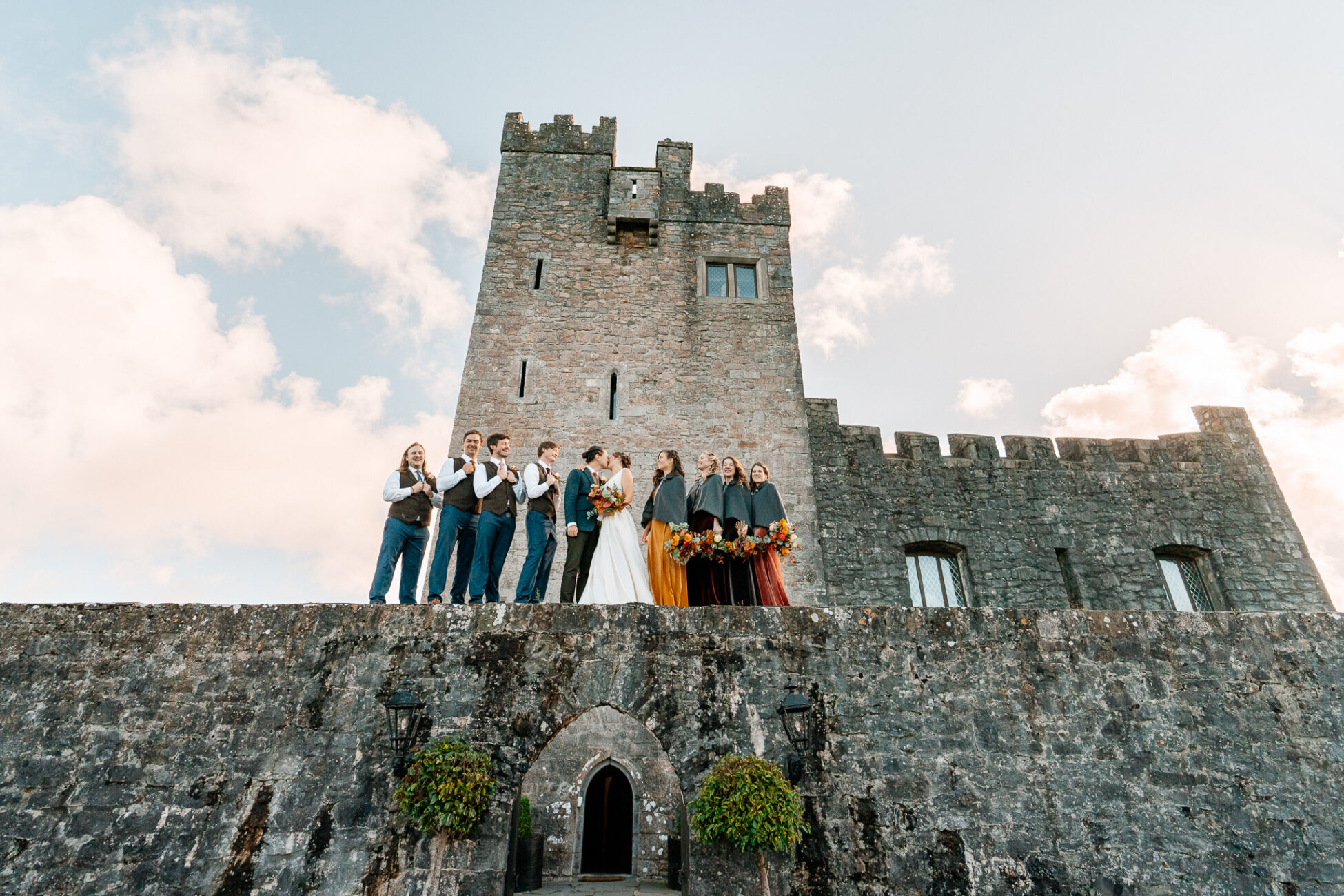 A group of people standing on a stone wall in front of a castle