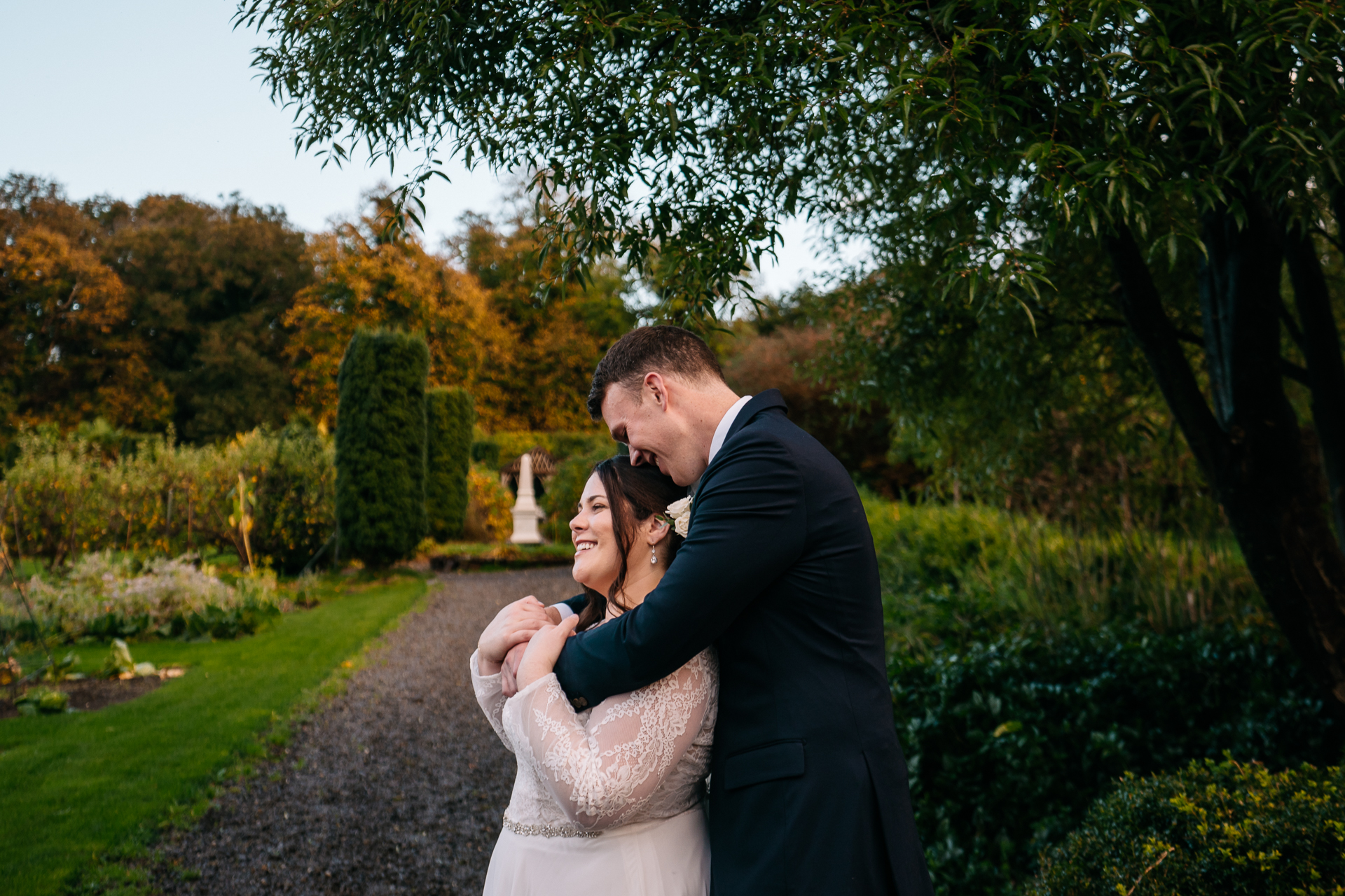 A man and woman kissing on a path in a park