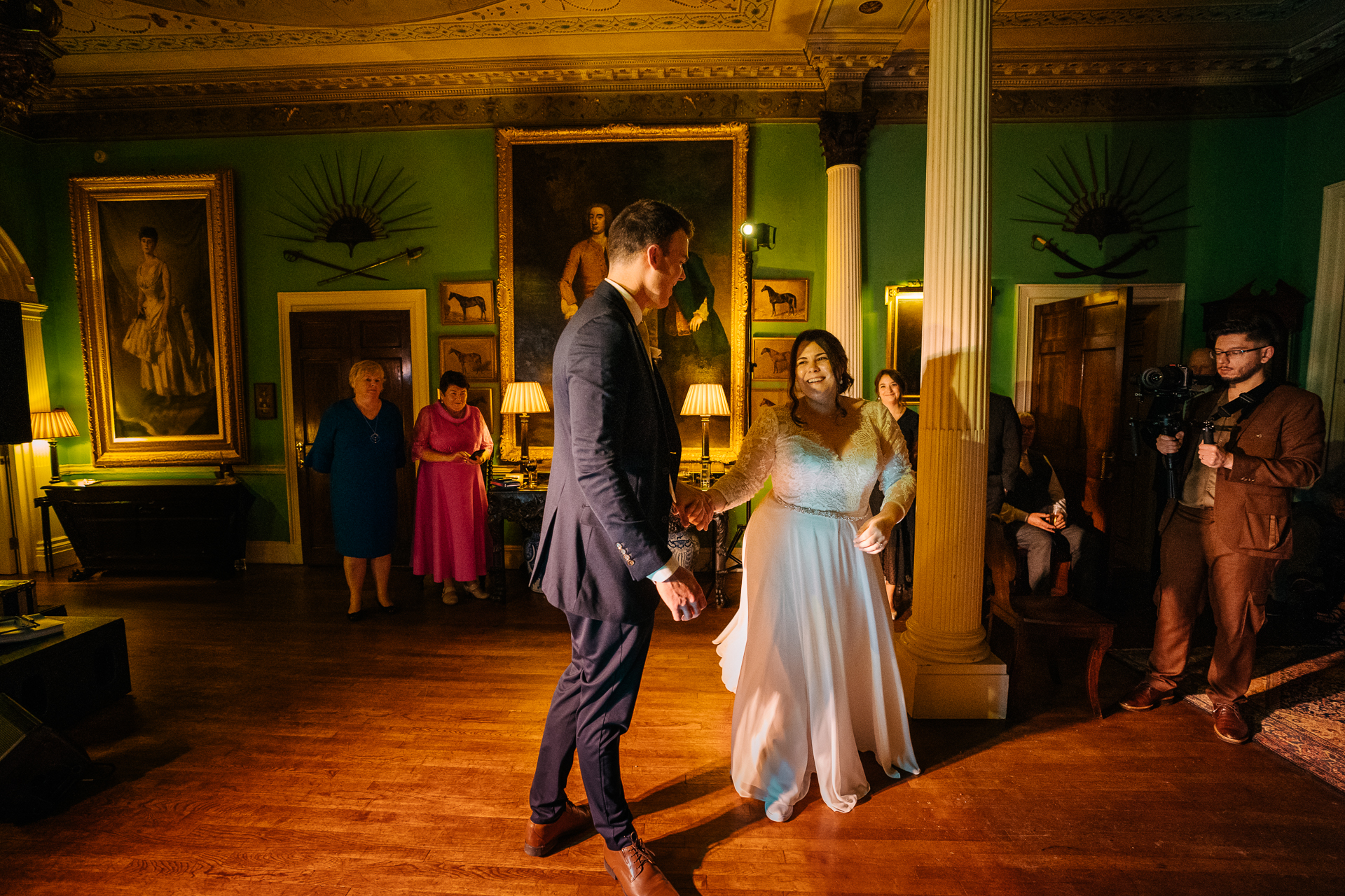 A man and woman walking down a hall with a man in a suit