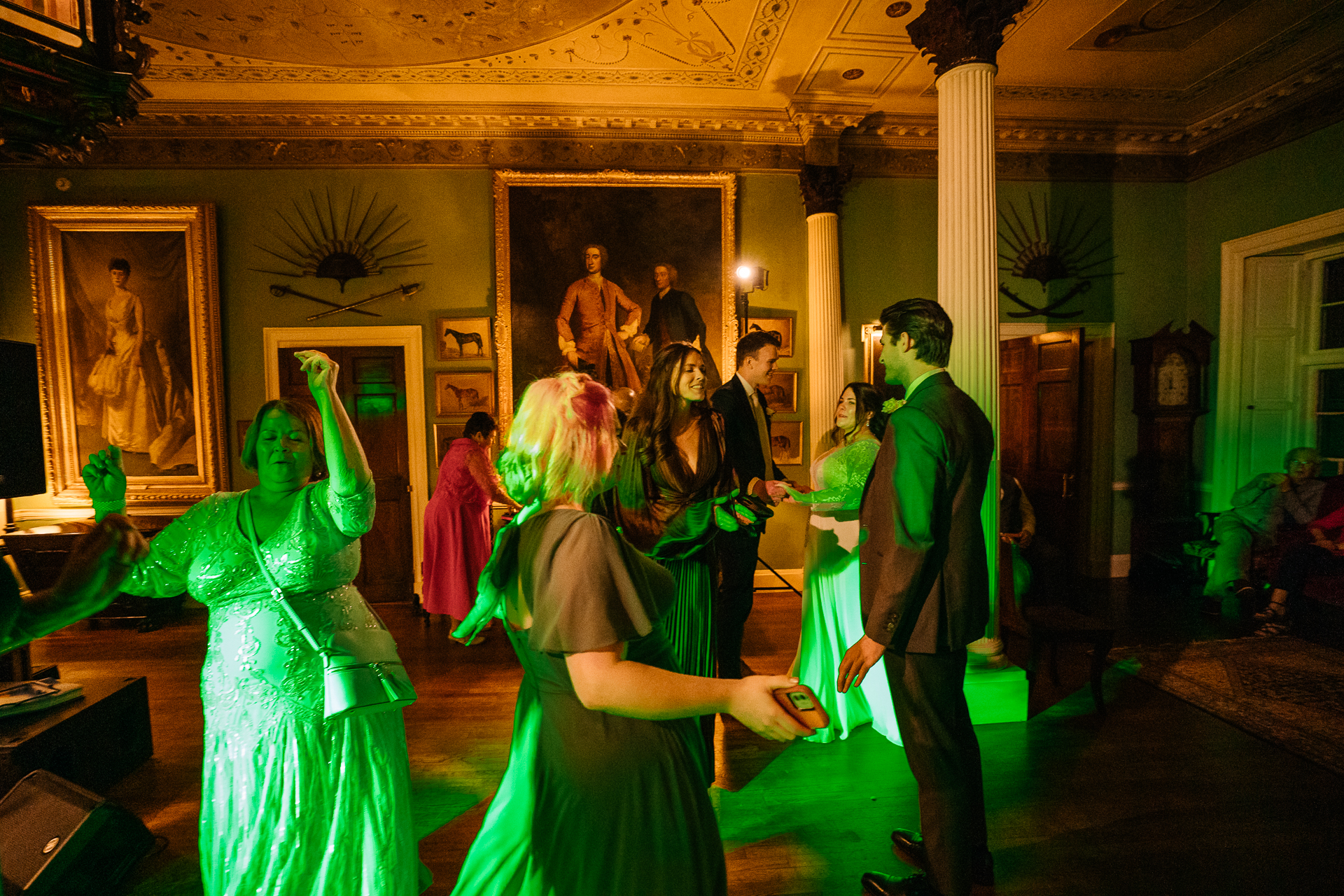 A group of people dancing in a room with art on the walls